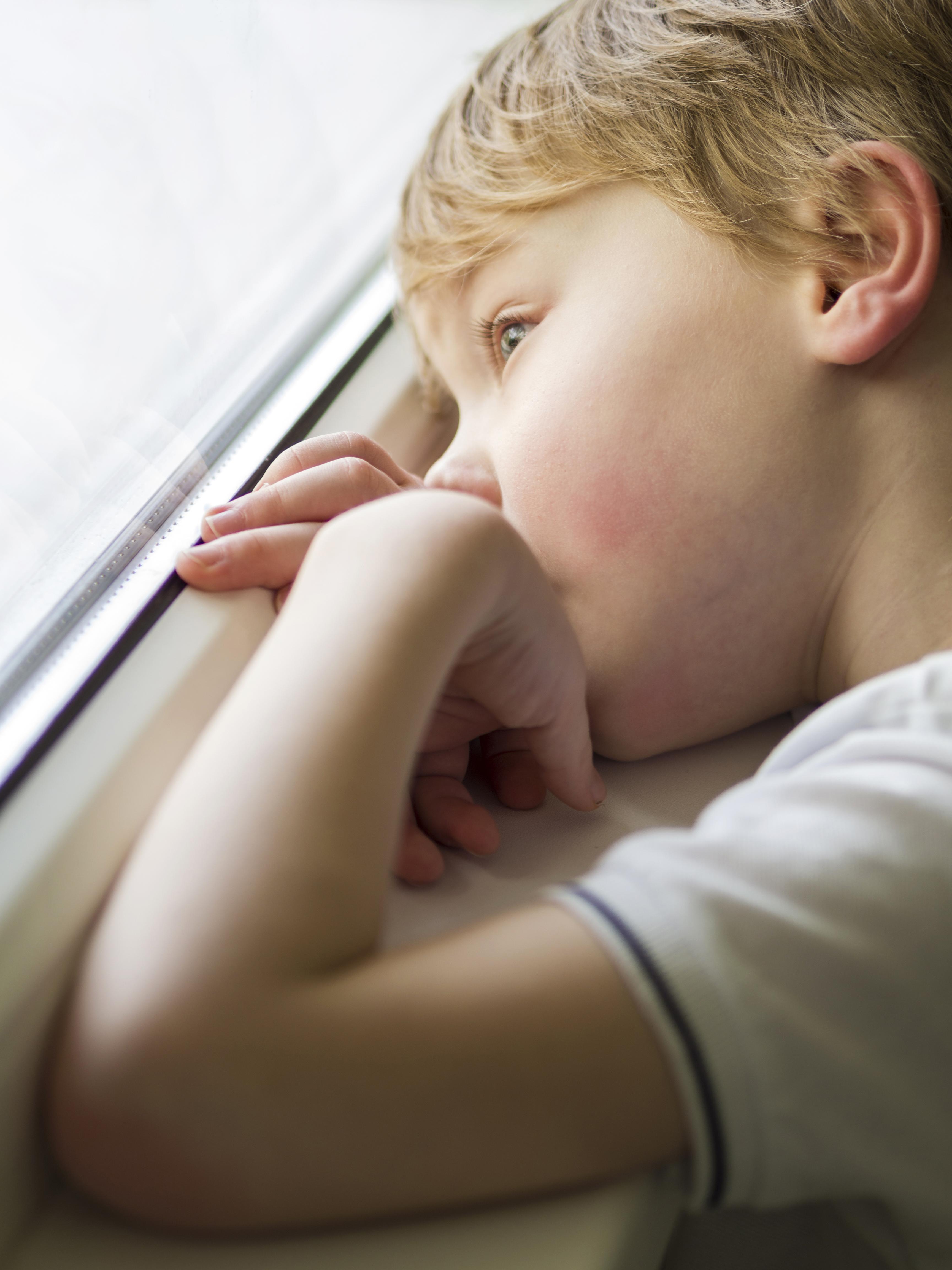 Ein trauriger kleiner Junge schaut aus dem Fenster | Quelle: Freepik