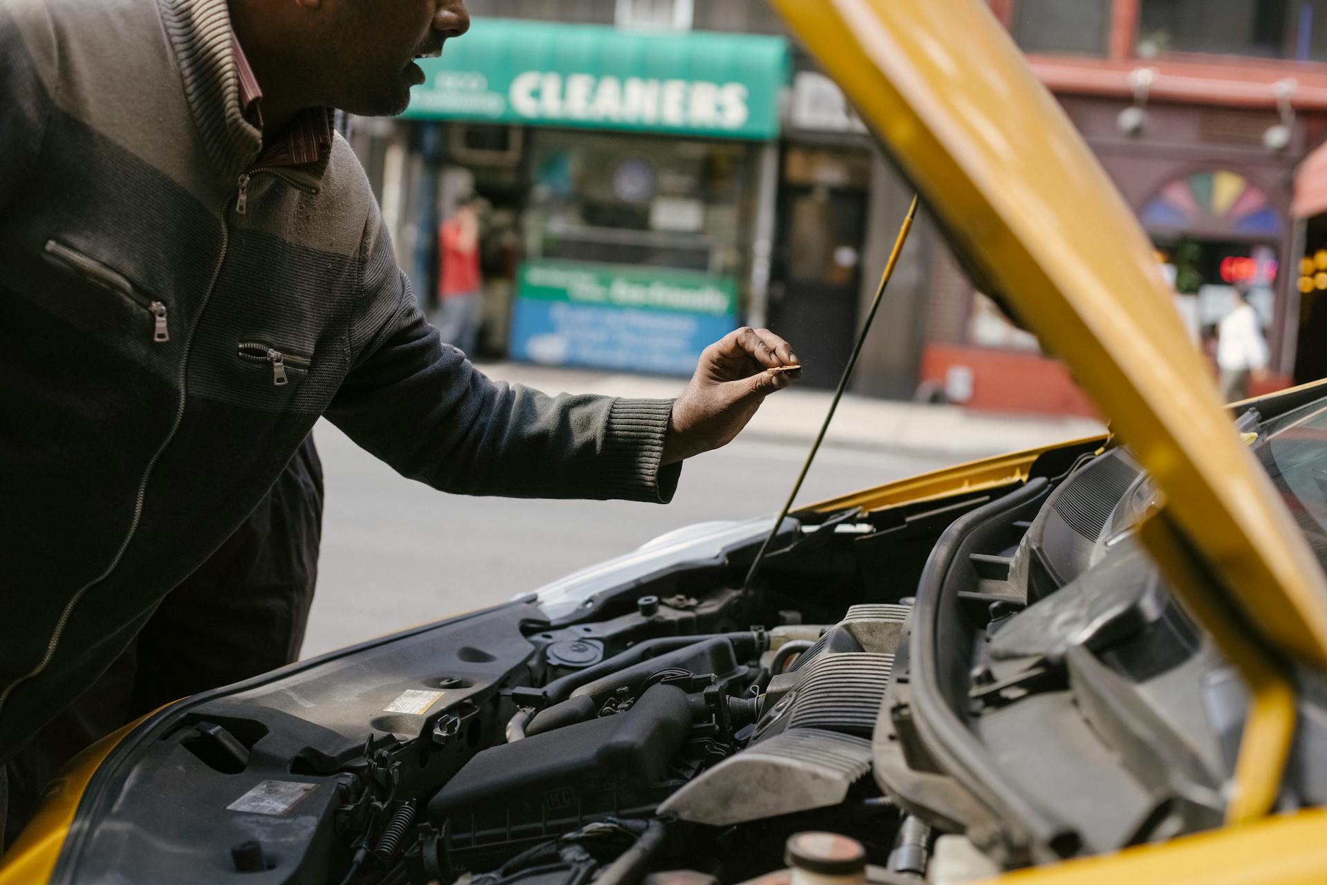 Ein Mann, der auf einen Automotor schaut | Quelle: Pexels