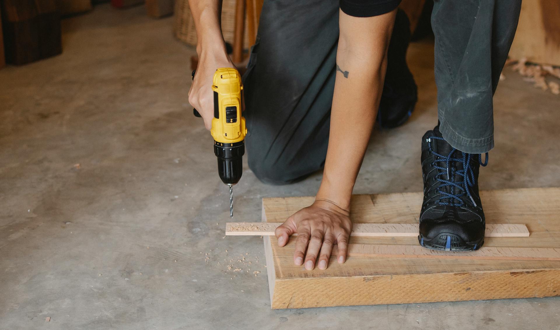 Ein Mann bohrt in Holz | Quelle: Pexels