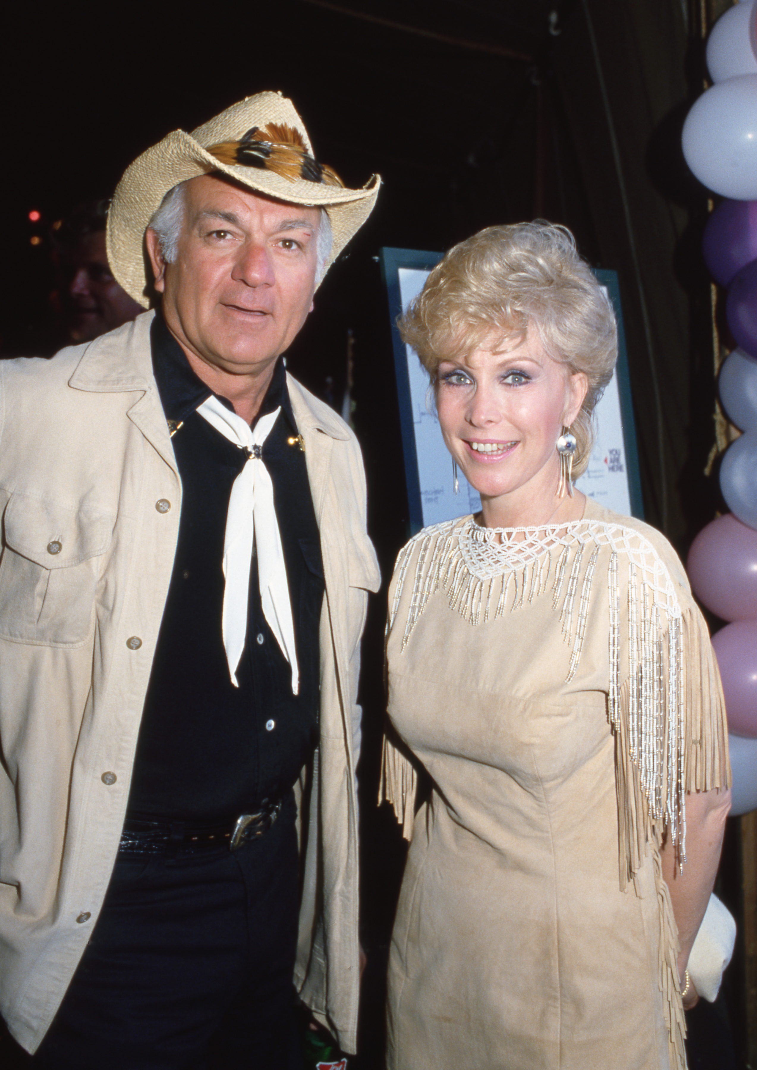 Barbara Eden trägt ein cremefarbenes und weißes Outfit an der Seite von Robert Mandan auf einer Party im Jahr 1982. | Quelle: Getty Images