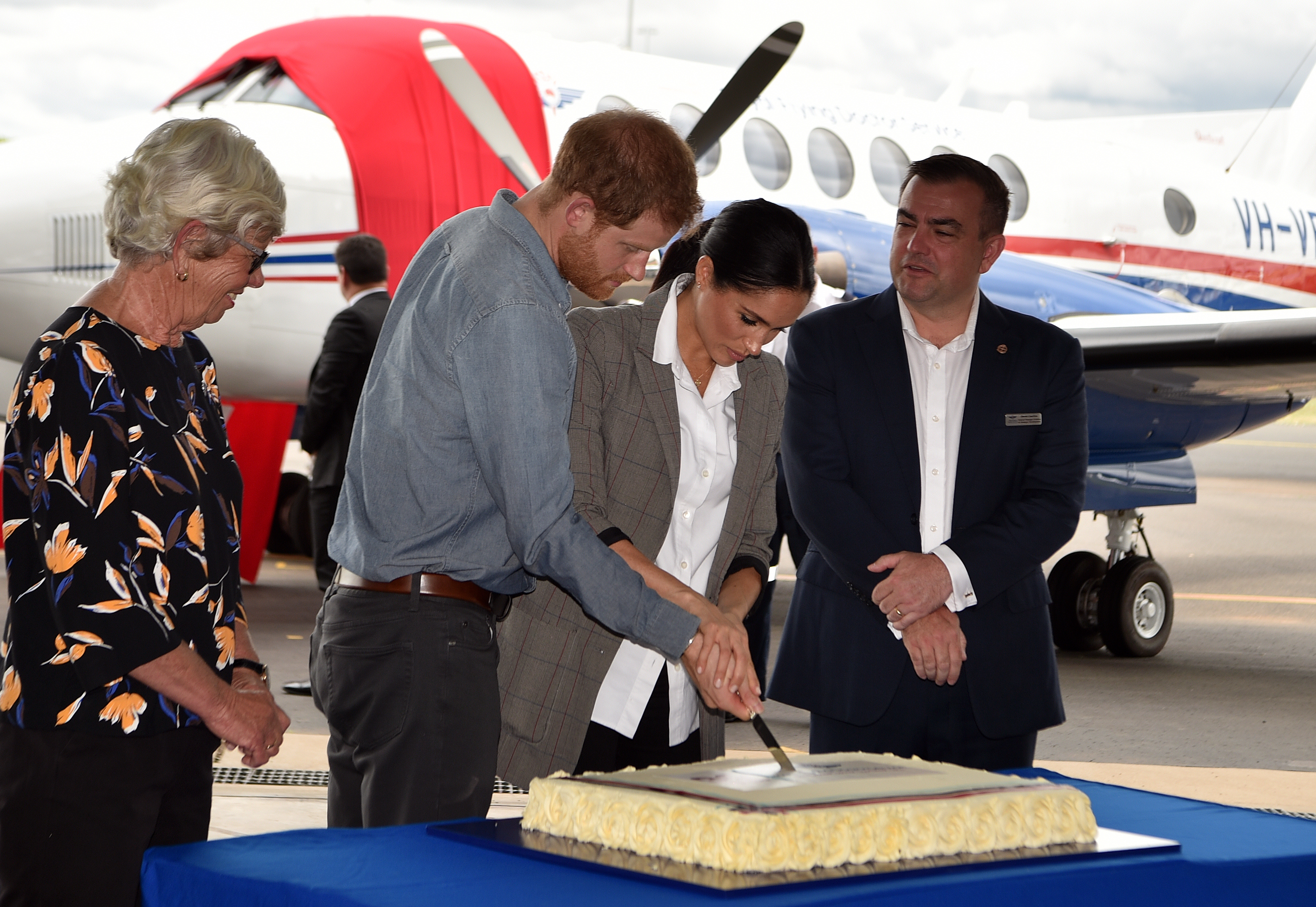 Prinz Harry und Meghan Markle schneiden am 17. Oktober 2018 am Dubbo Regional Airport in Australien eine Jubiläumstorte zum 90-jährigen Bestehen des australischen Royal Flying Doctor Service an | Quelle: Getty Images