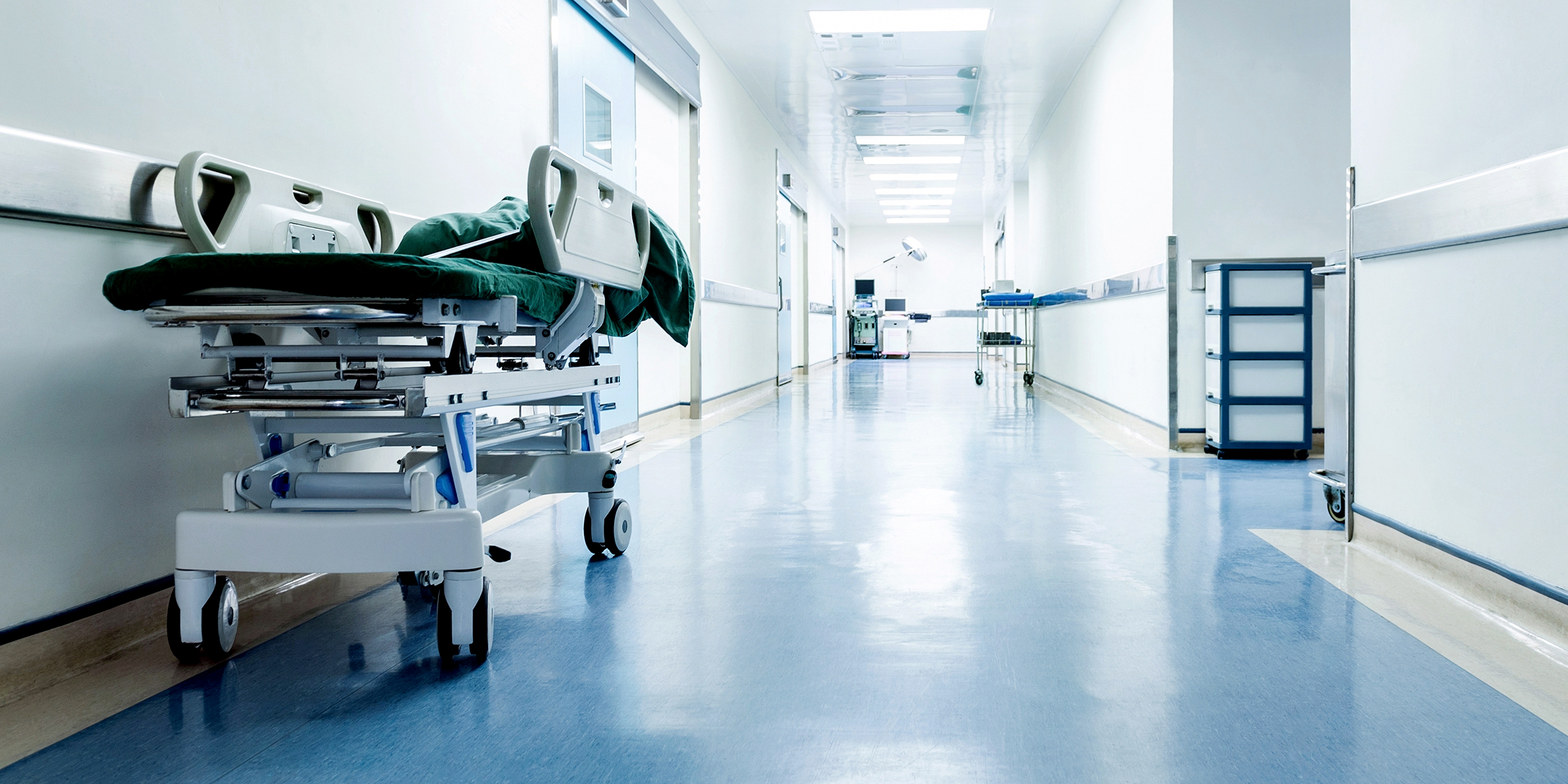 Ein leerer Krankenhausflur mit einer an der Wand geparkten Bahre | Quelle: Shutterstock