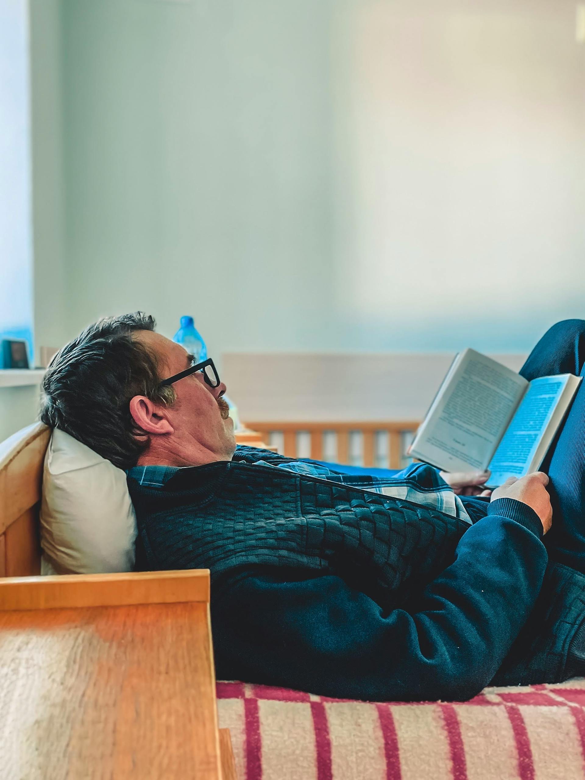 Ein Mann, der im Bett liegt und liest | Quelle: Pexels