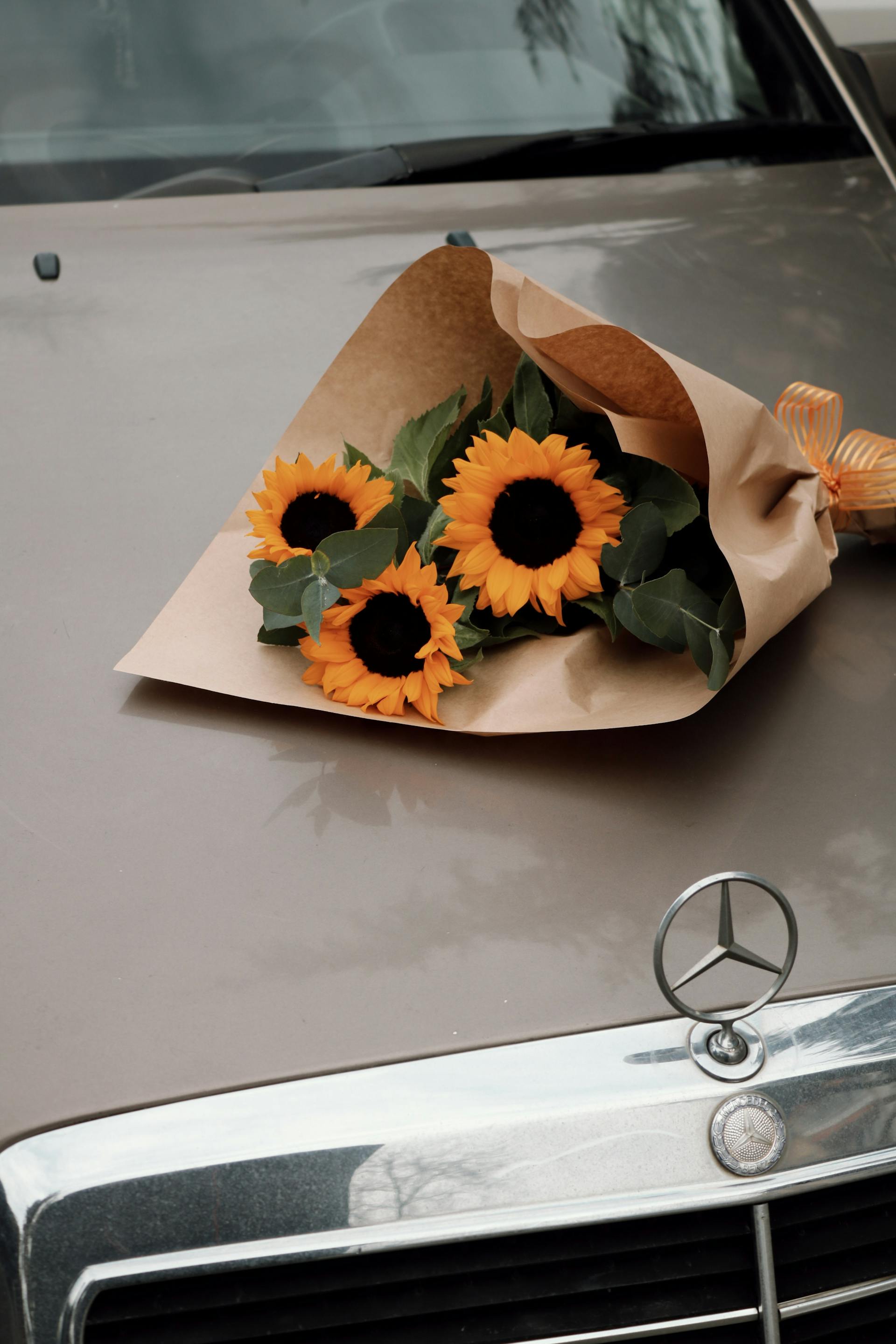 Ein Blumenstrauß aus Sonnenblumen auf einem Auto | Quelle: Pexels