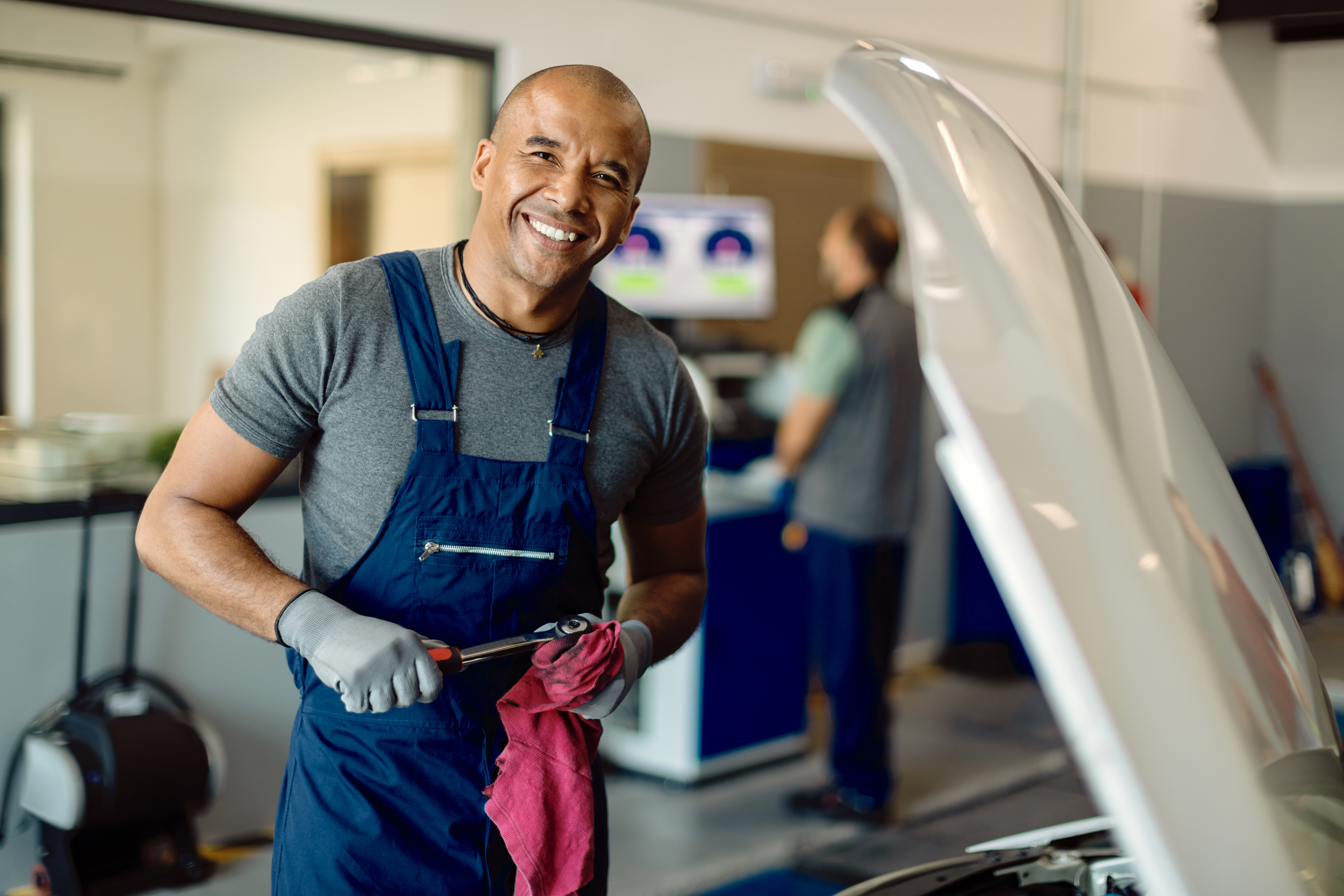 Ein Mechaniker lächelt bei der Arbeit | Quelle: FreePik