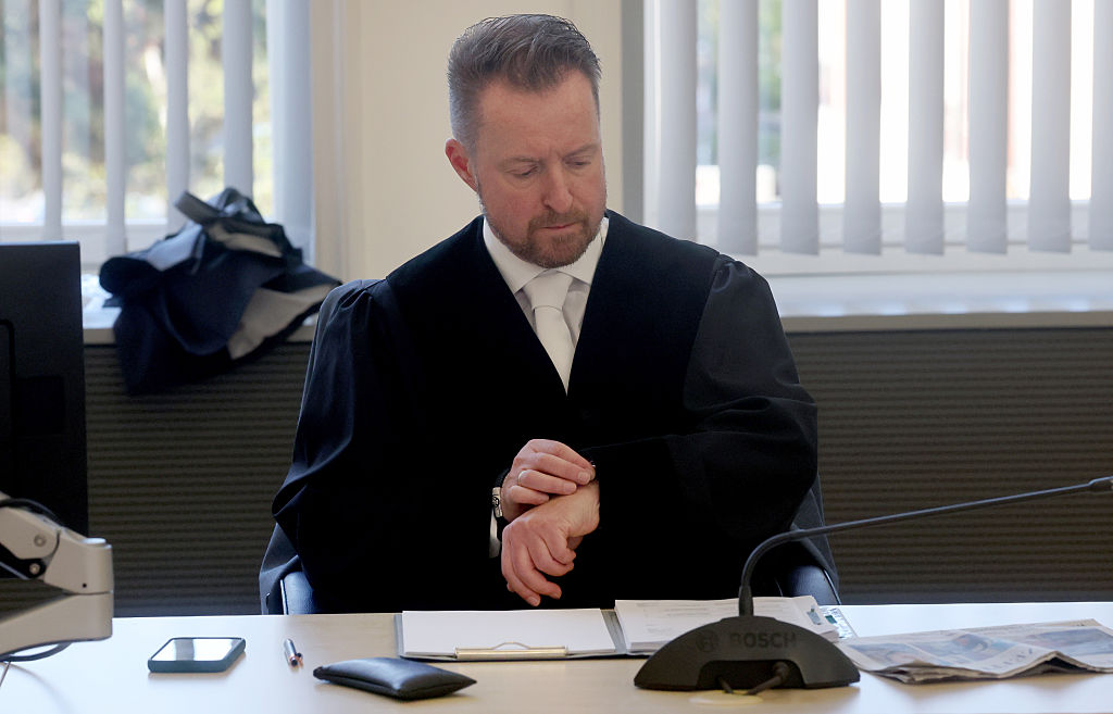 28. April 2026, Mecklenburg-Vorpommern, Rostock: Der leitende Staatsanwalt Harald Nowack blickt vor Beginn des Mordprozesses im Fall Fabian im Gerichtssaal des Landgerichts auf seine Uhr. | Quelle: Getty Images