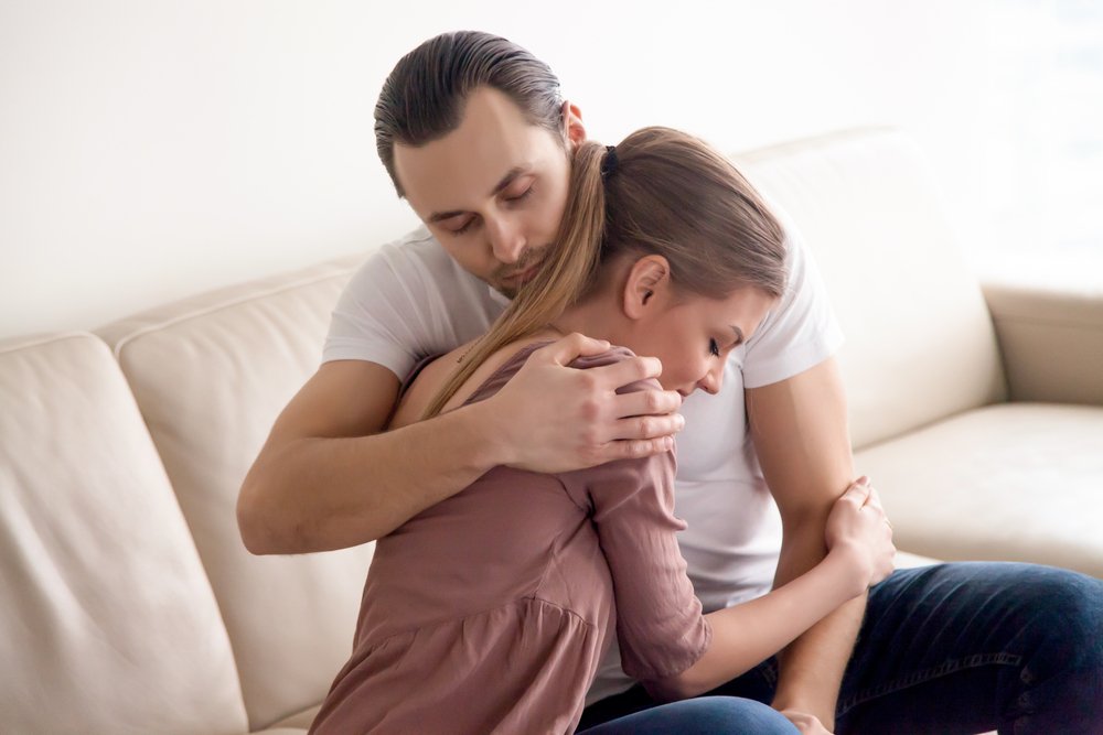 Junge zärtliche Mann umarmte seine Frau. I Quelle: Shutterstock
