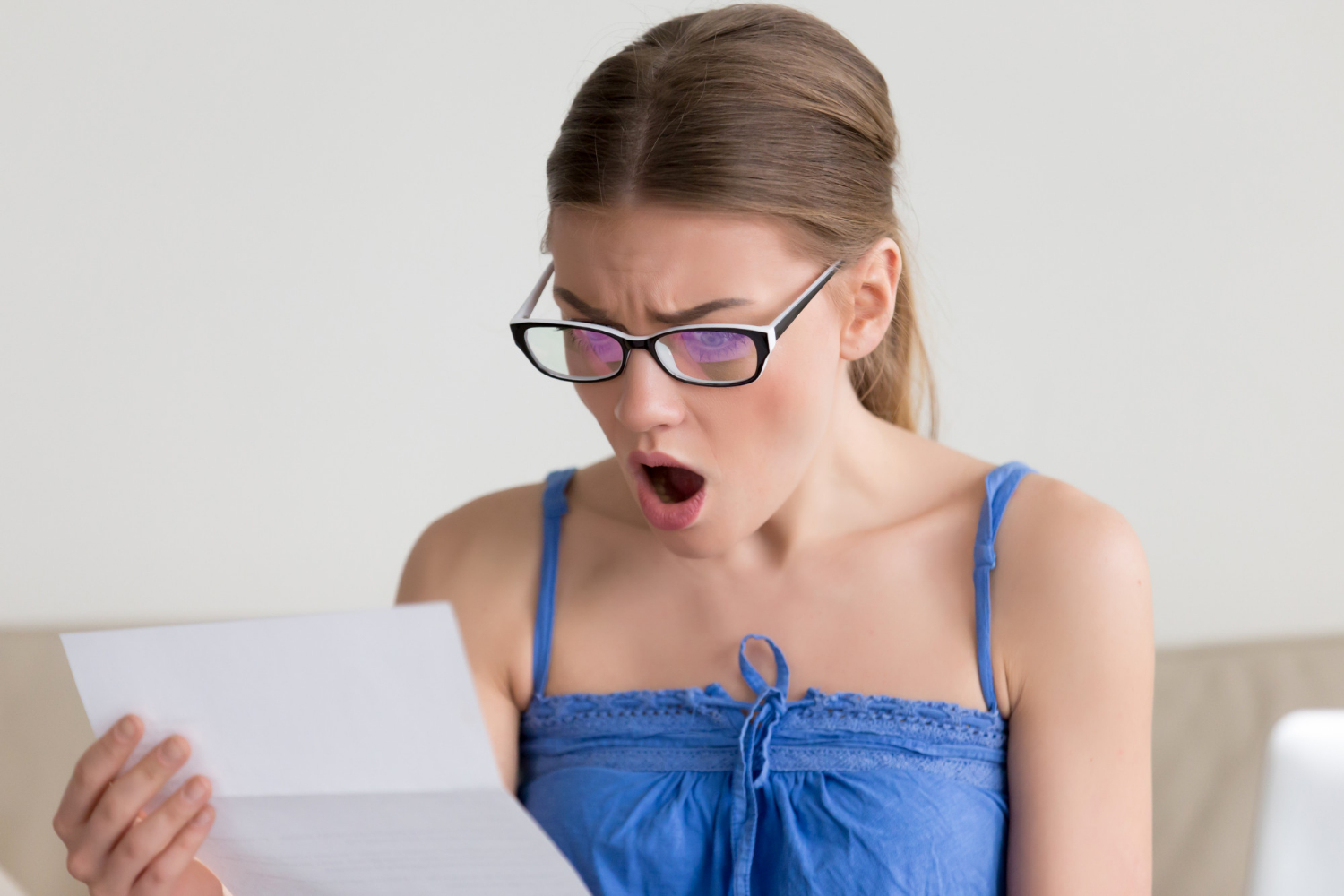 Eine schockierte Frau liest einen Brief | Quelle: Freepik