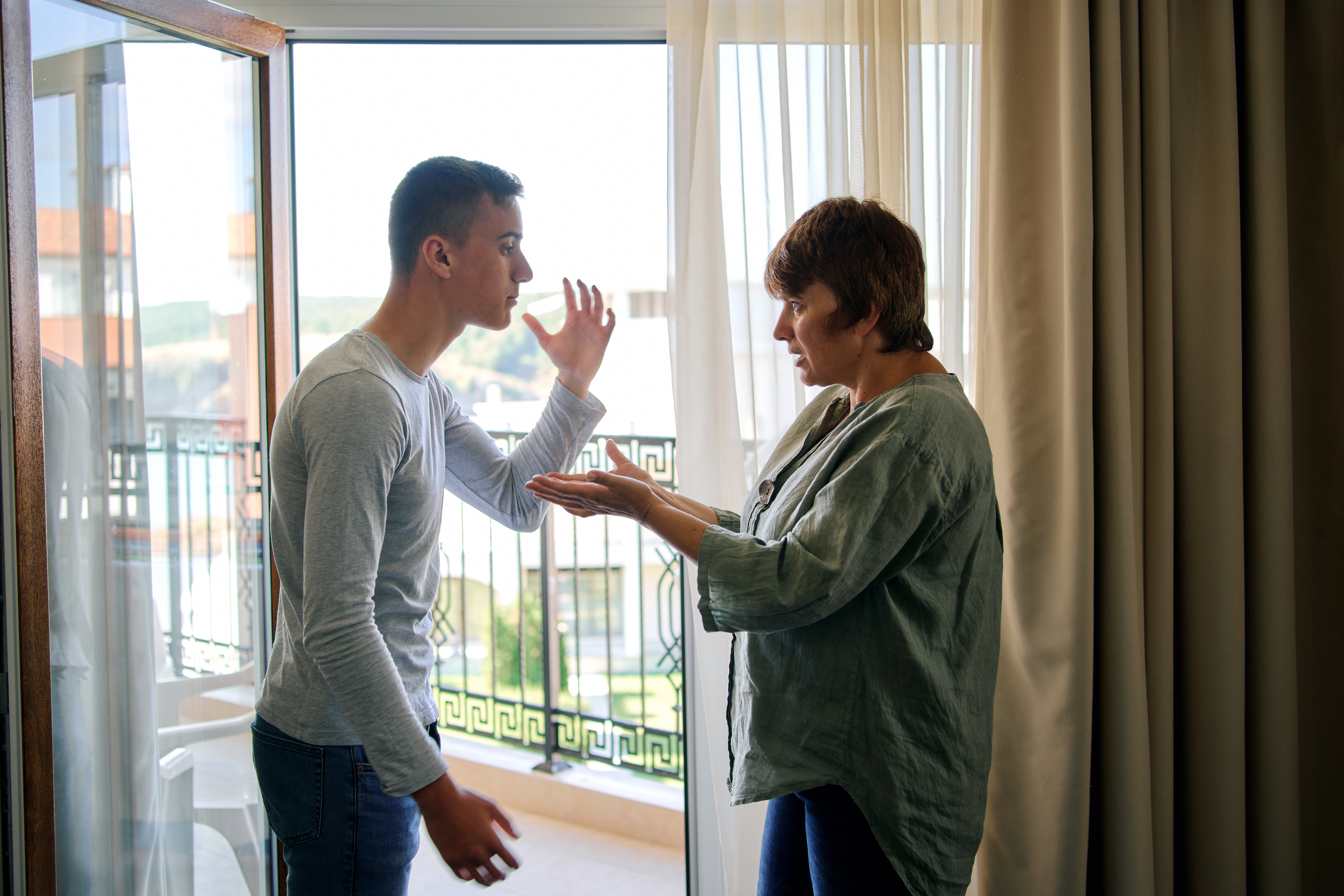 Ein junger Mann streitet sich mit seiner Mutter | Quelle: Getty Images