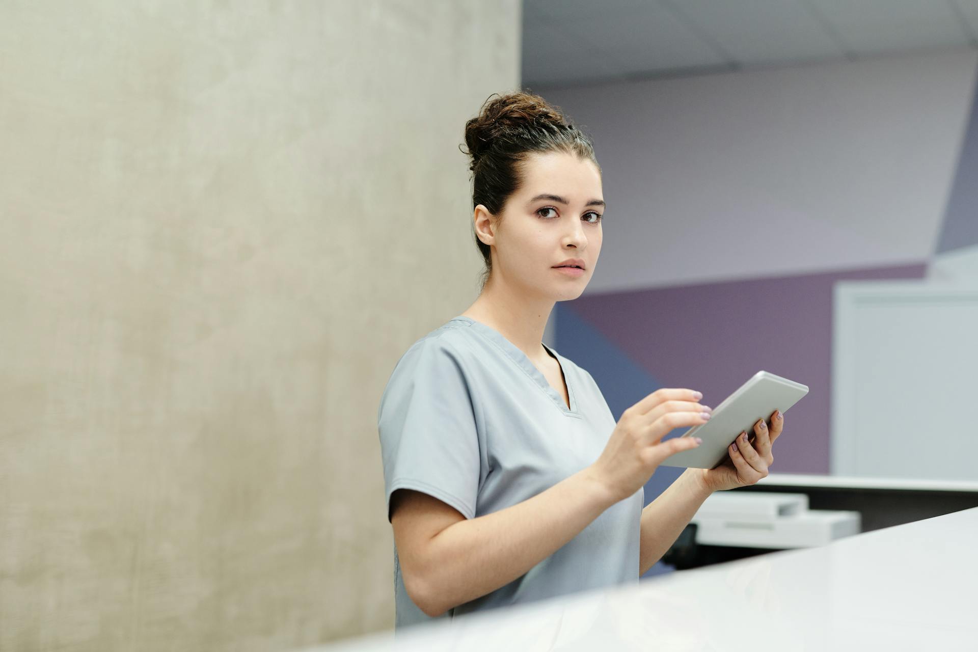 Eine Empfangsdame mit einem Tablet-Computer in einem Krankenhaus | Quelle: Pexels