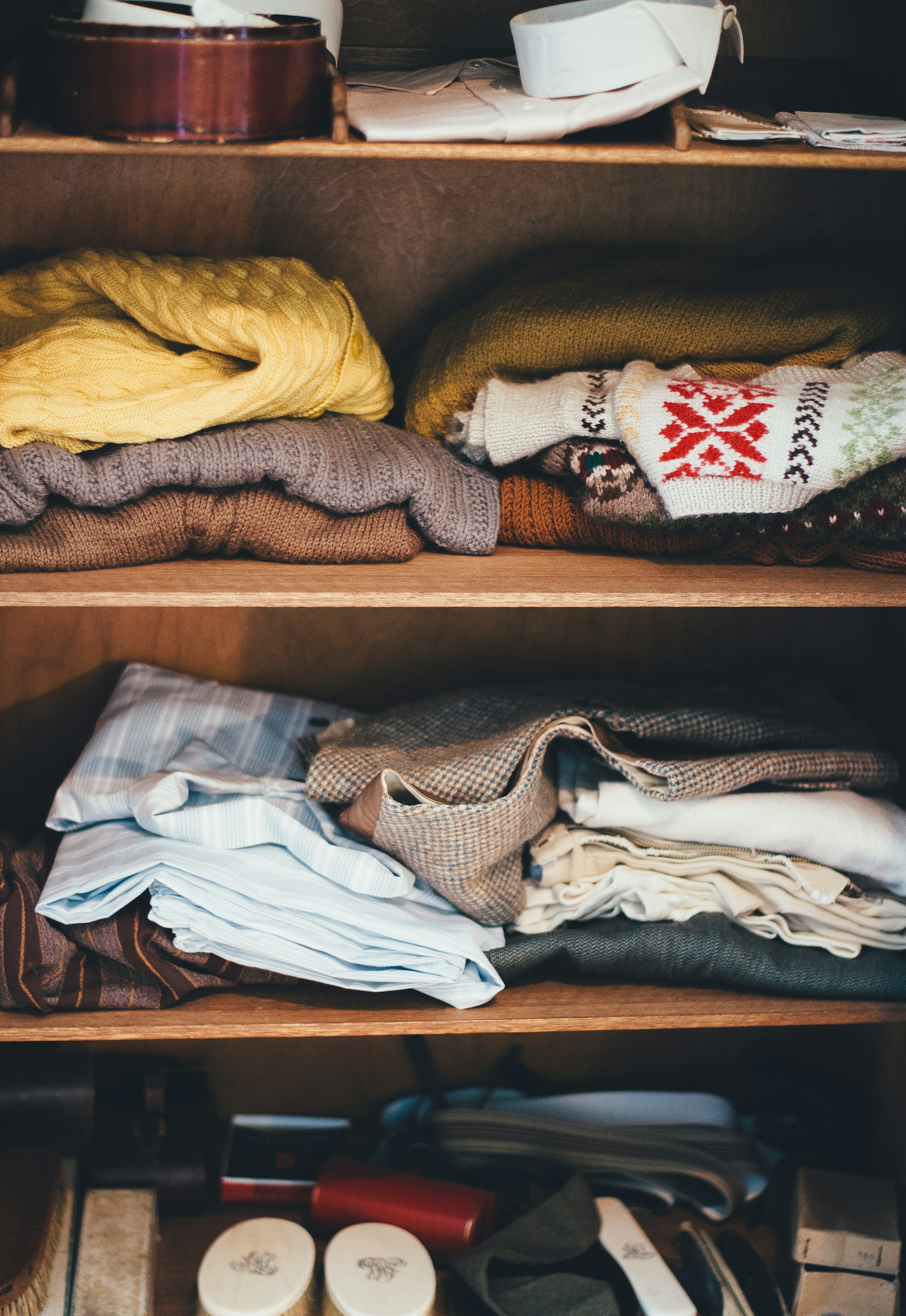 Kleidung auf einem Regal in einem Schrank | Quelle: Unsplash