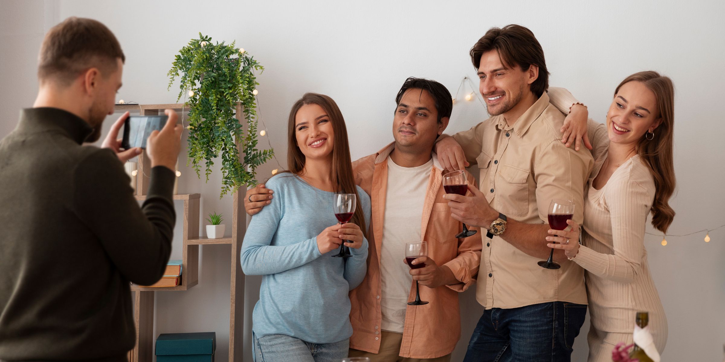 Eine Gruppe fröhlicher Leute, die auf einer Party posieren, während ein Foto von ihnen gemacht wird | Quelle: Magnific
