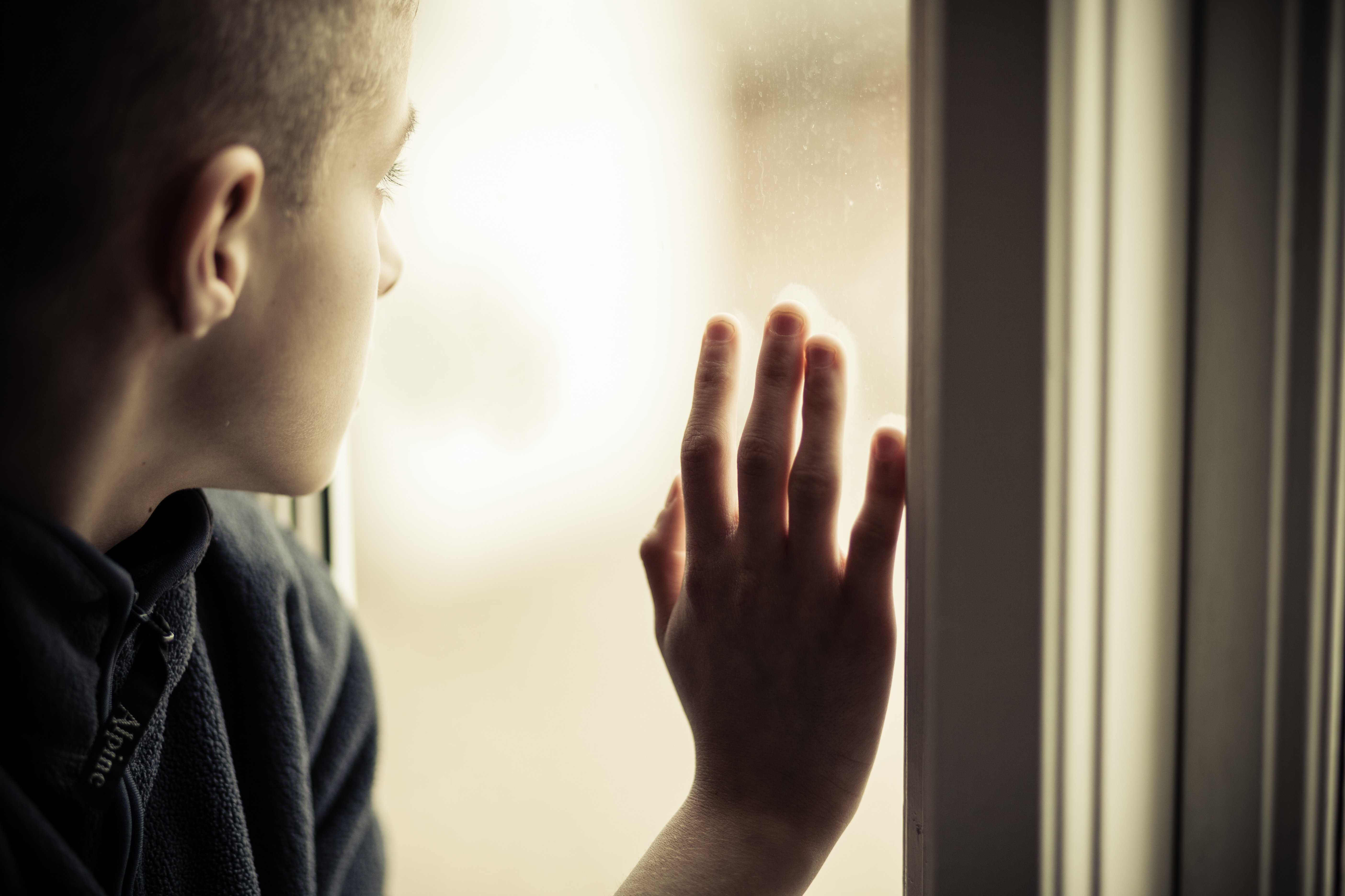 Einsamer Junge, der aus einem Fenster starrt. | Quelle: Shutterstock