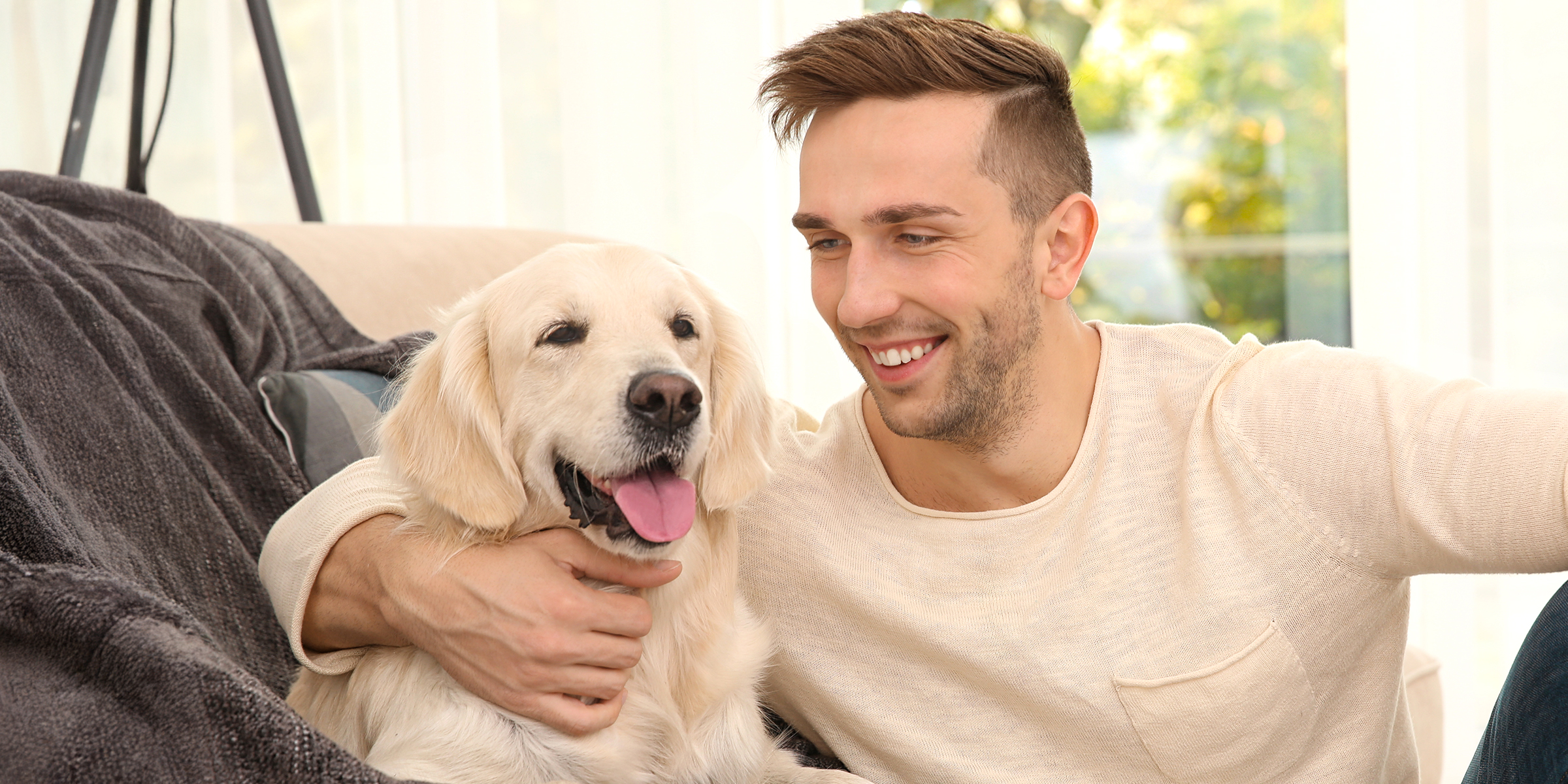 Ein Mann kuschelt mit einem Hund | Quelle: Shutterstock