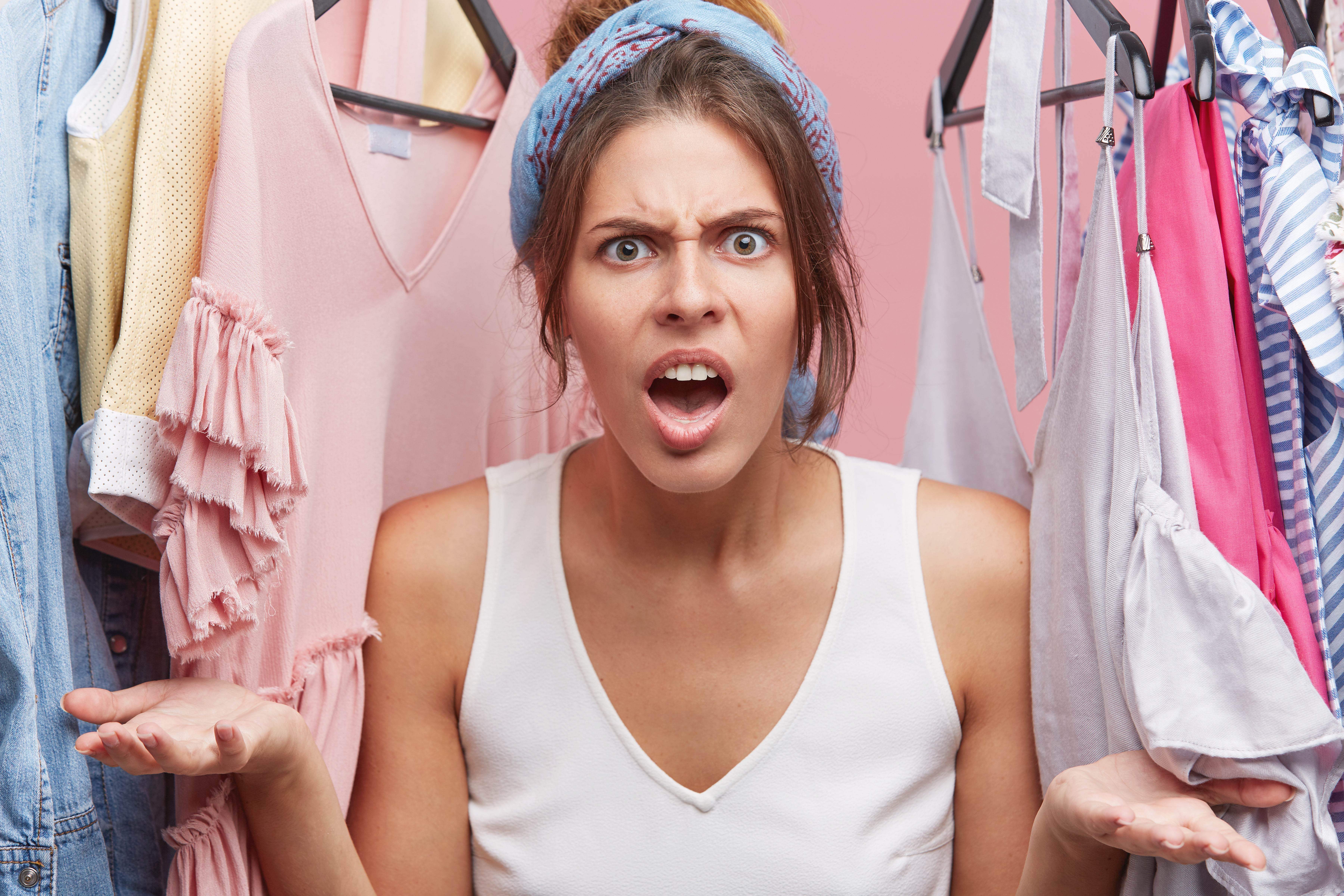 Frau wütend in ihrem Kleiderschrank | Quelle: wayhomestudio auf Freepik