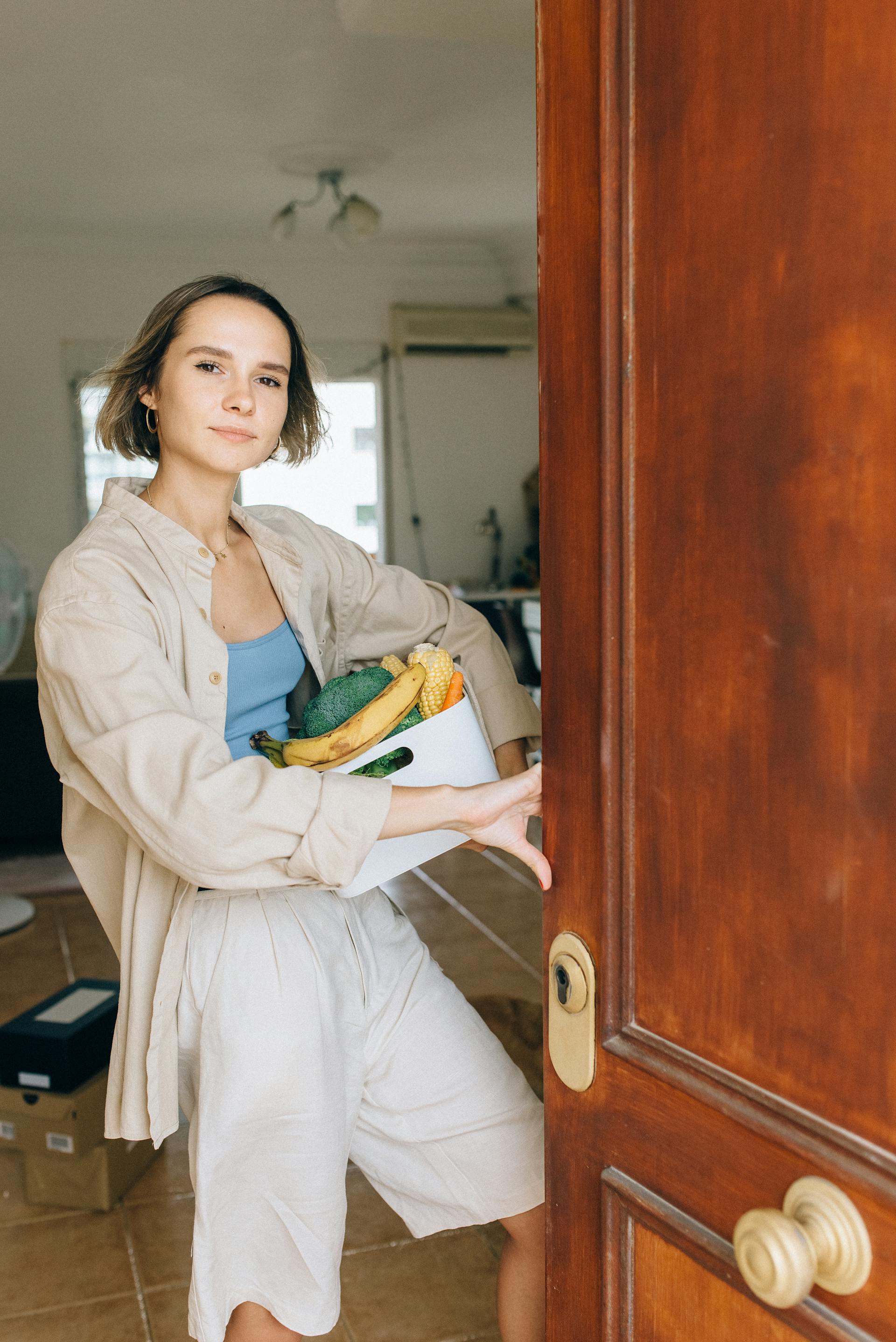 Eine Frau steht in der offenen Tür ihrer Wohnung | Quelle: Pexels
