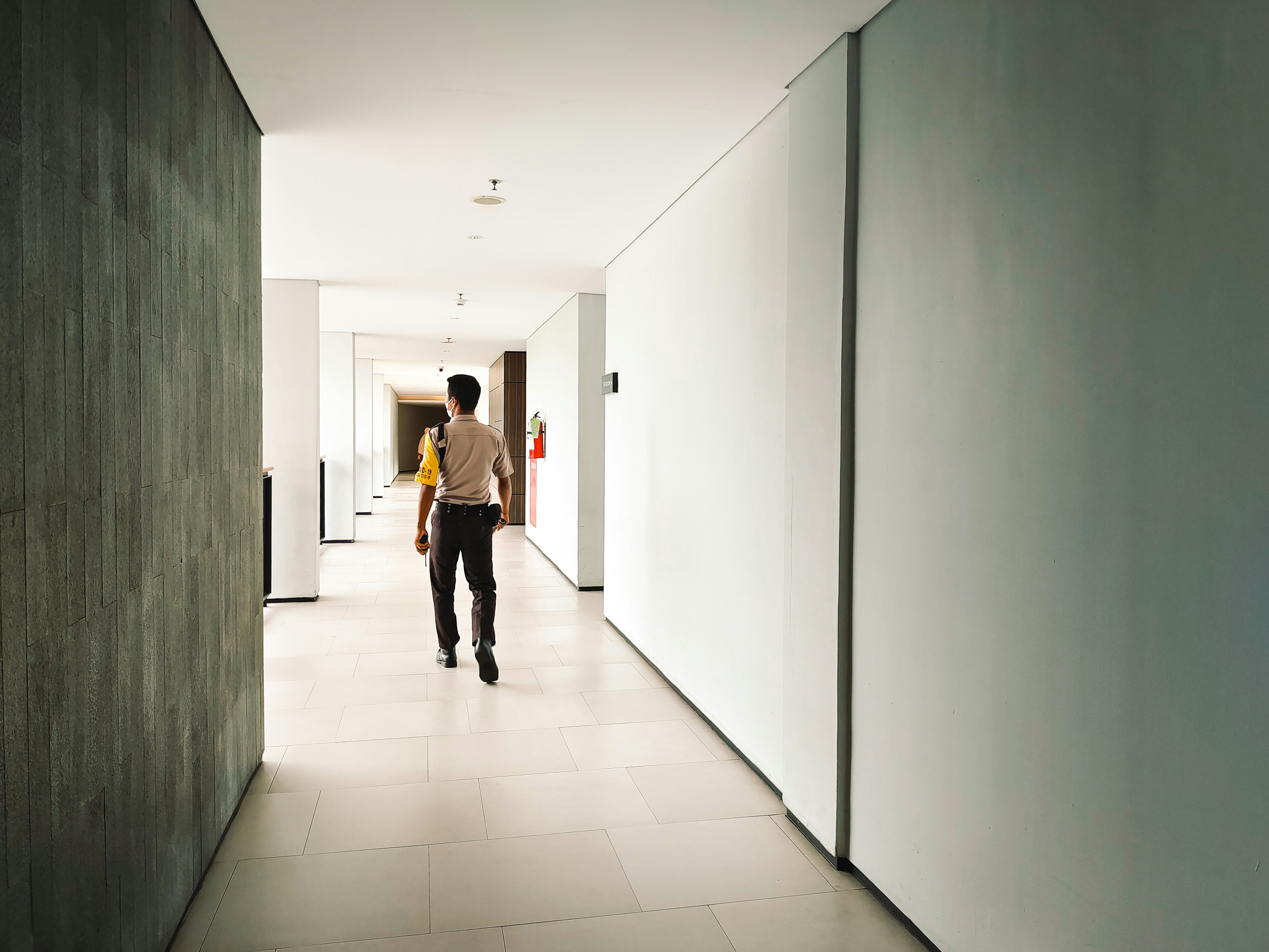 Ein Wachmann, der durch einen Korridor geht | Quelle: Pexels