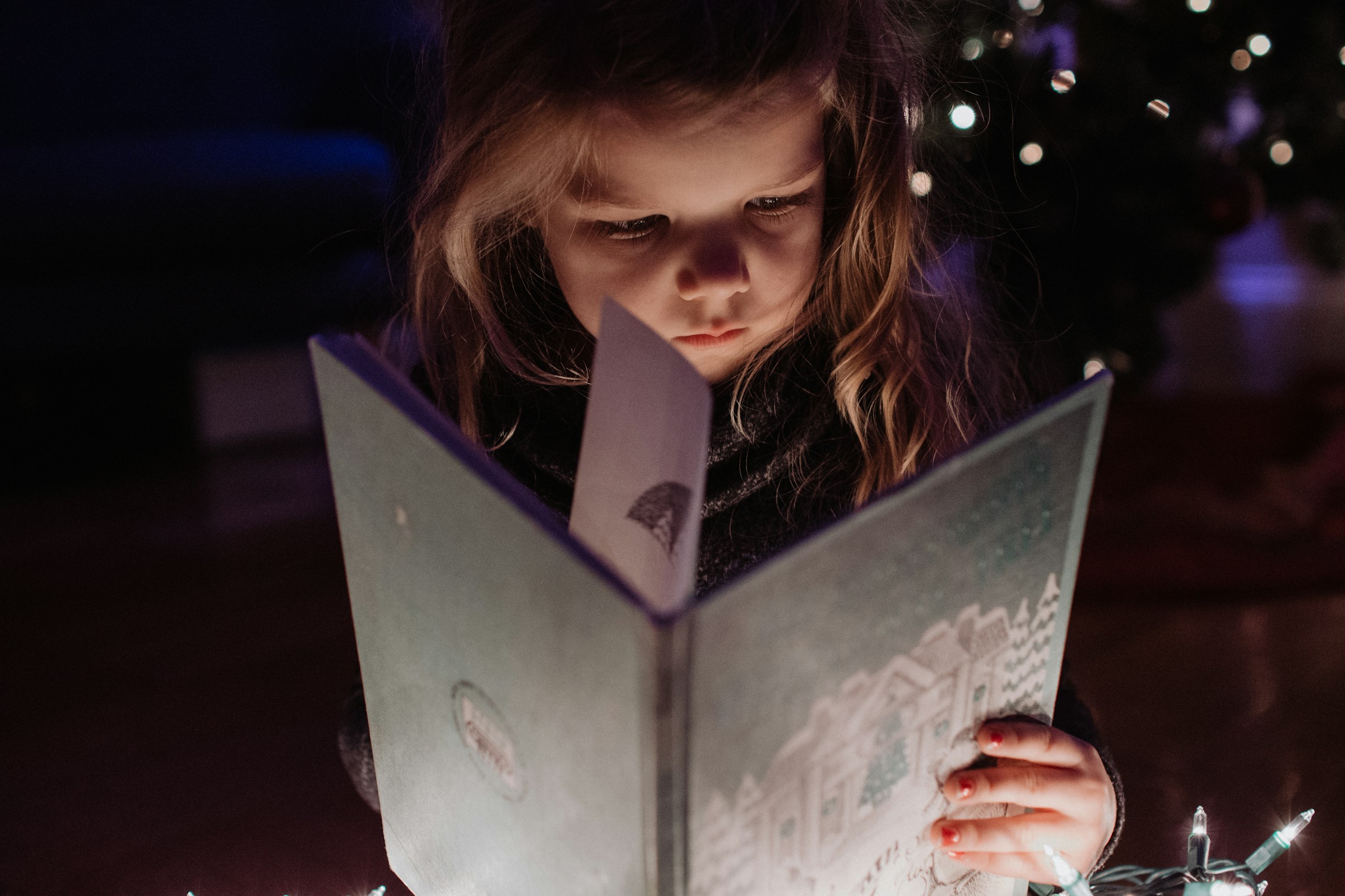 Ein kleines Mädchen hält ein Buch in der Hand | Quelle: Unsplash