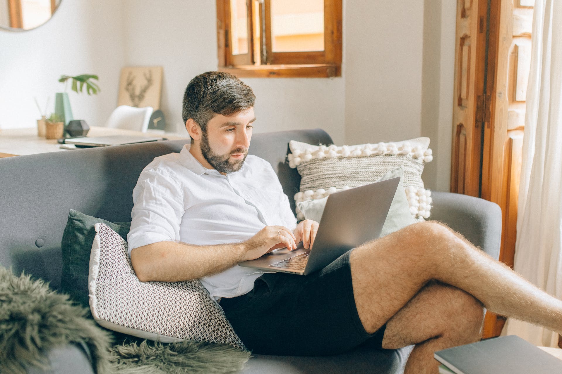 Mann mit Laptop auf der Couch | Quelle: Pexels