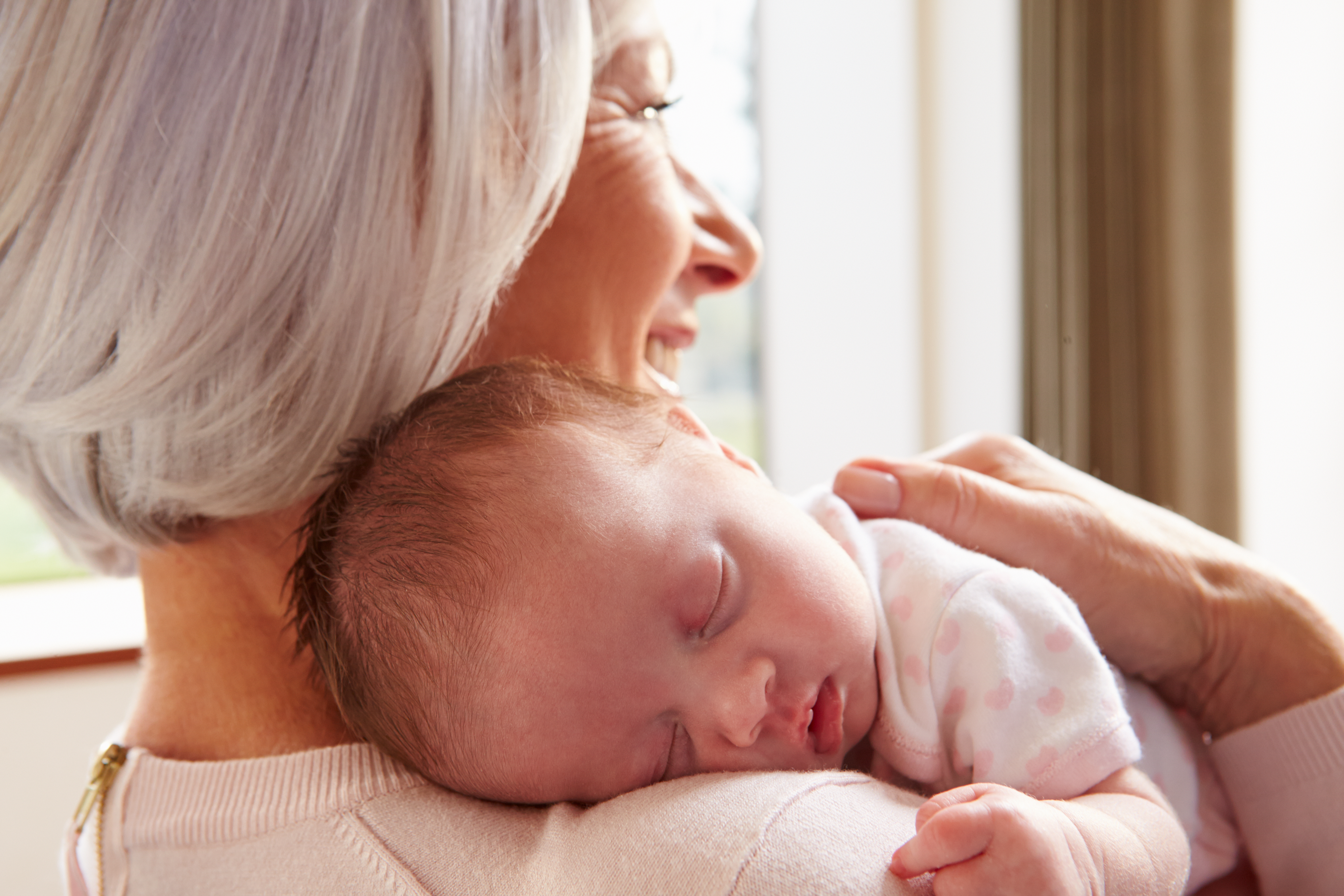 Eine Großmutter hält ihr neugeborenes Enkelkind | Quelle: Shutterstock