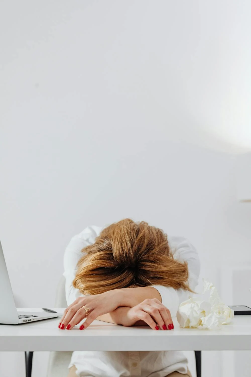 Eine müde Frau, die auf ihrem Tisch liegt | Quelle: Pexels