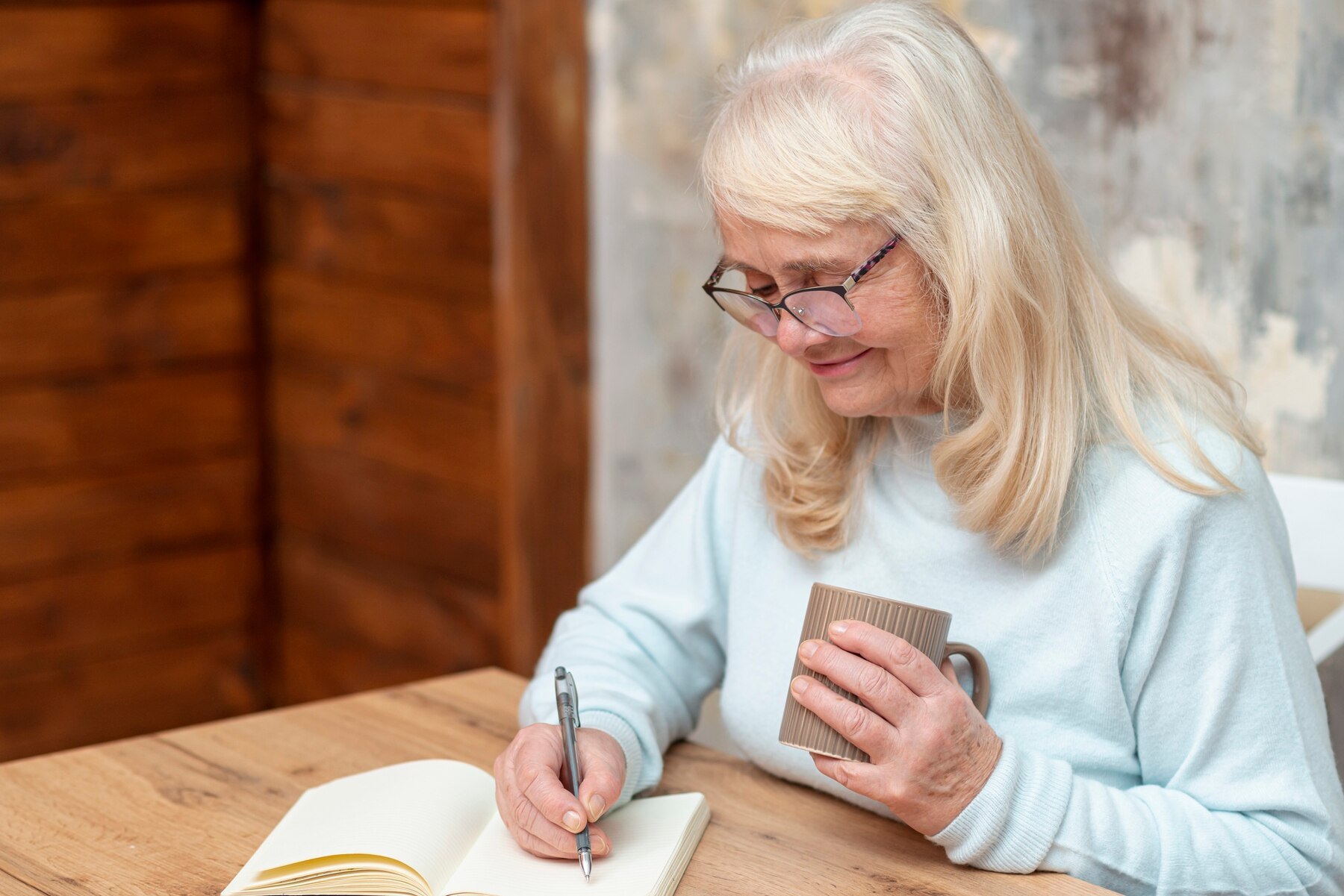 Eine Frau schreibt in ihr Notizbuch | Quelle: Freepik