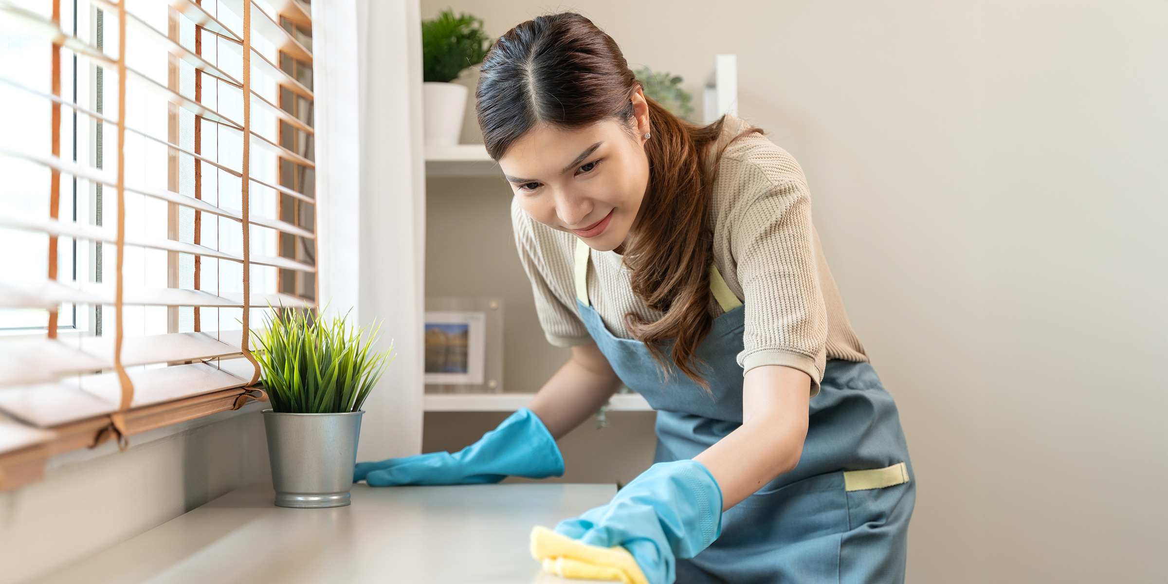 Eine Frau wischt eine Arbeitsplatte ab | Quelle: Shutterstock