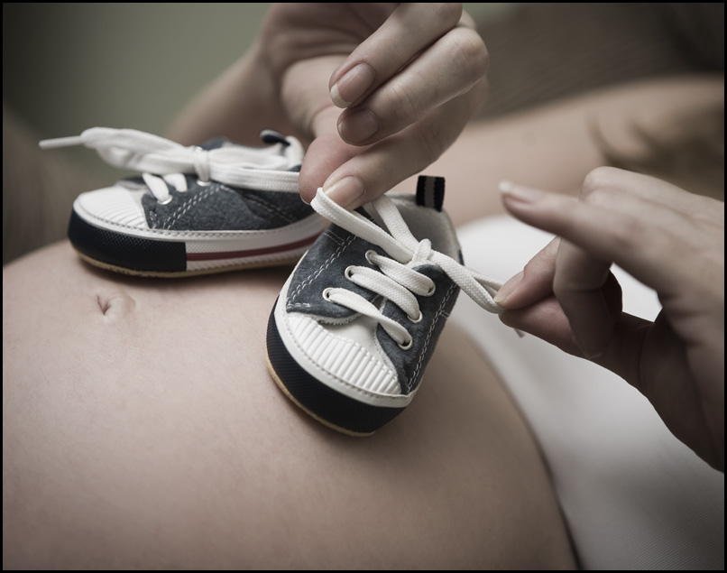 Babyschuhe auf dem Bauch einer schwangeren Frau | Quelle: Flickr