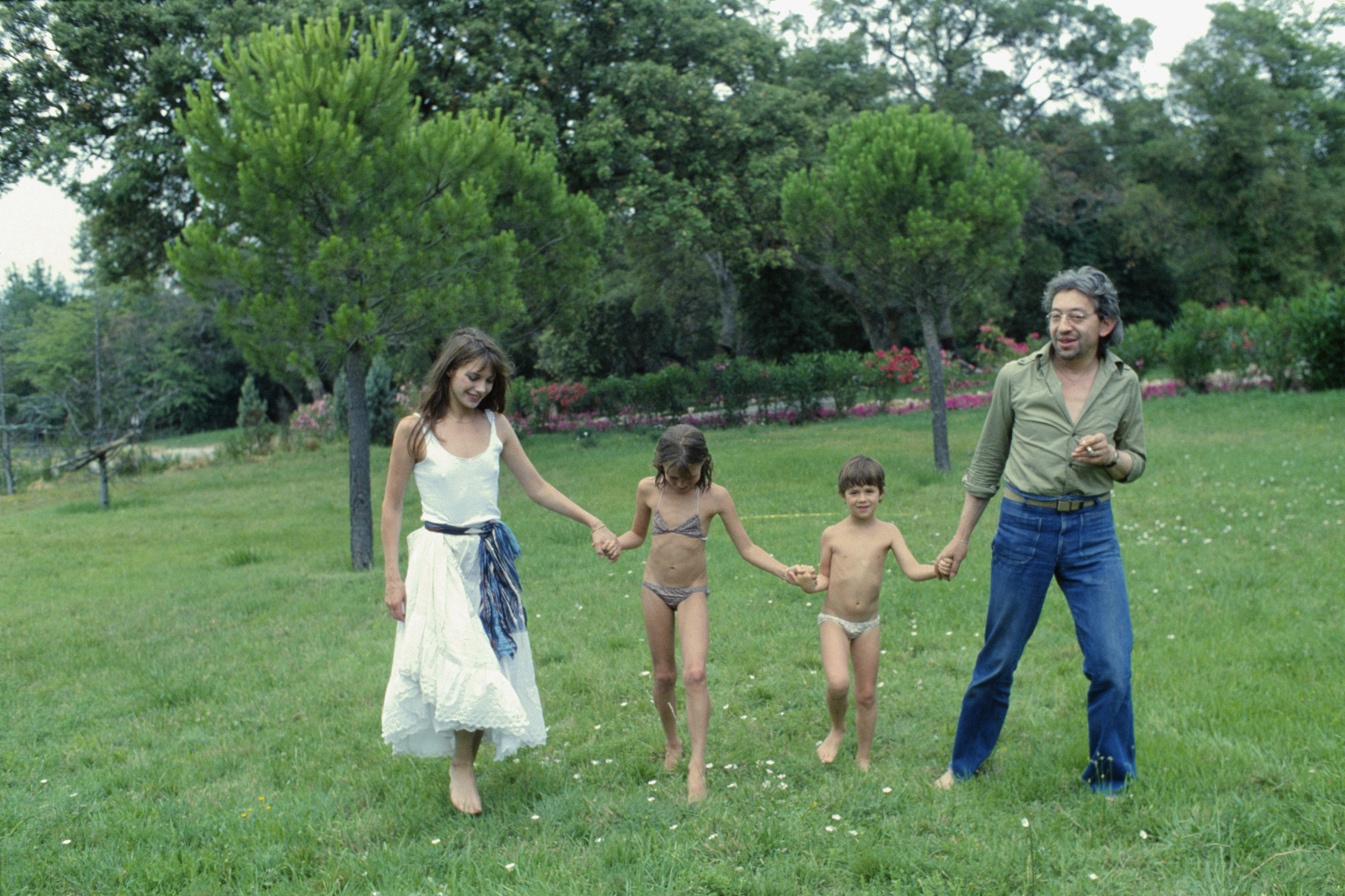 Jane Birkin, Serge Gainsbourg, Charlotte Gainsbourg (R) und Kate Barry (L) in Saint-Tropez am 1. Januar 1977 | Quelle: Getty Images