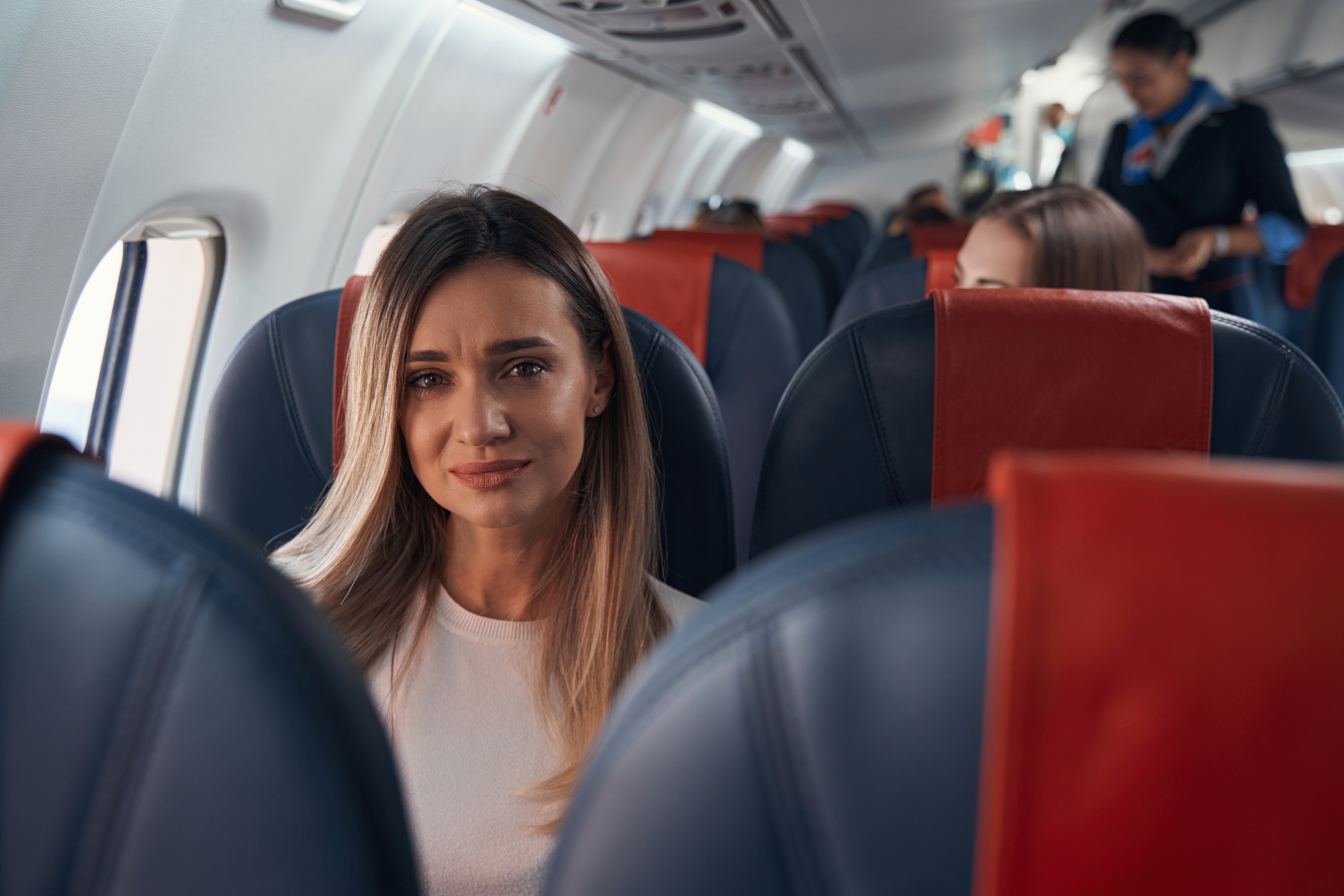 Eine traurige Frau in einem Flugzeug | Quelle: Shutterstock