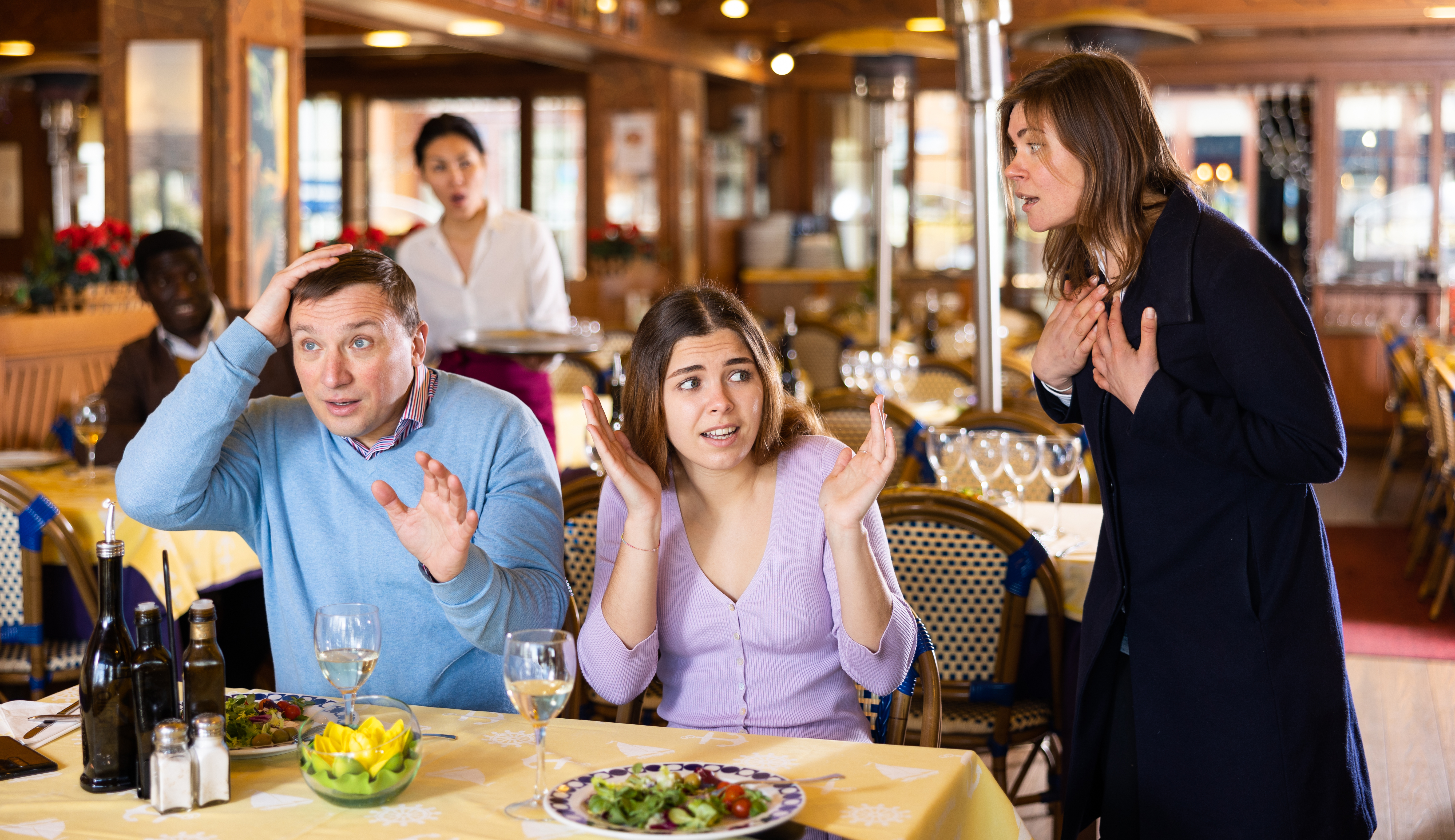 Menschen, die sich in einem Restaurant streiten | Quelle: Getty Images