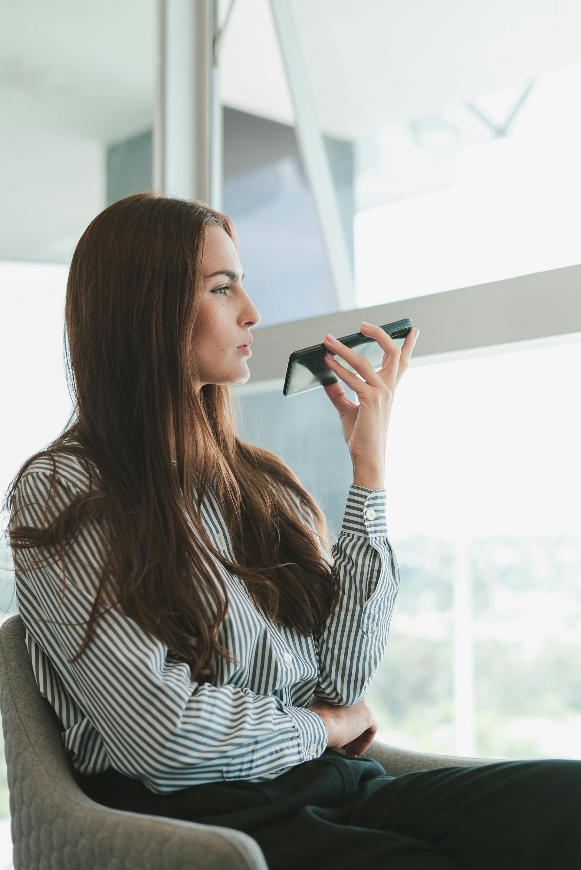 Eine Frau sitzt auf einem Stuhl und spricht am Telefon | Quelle: Pexels