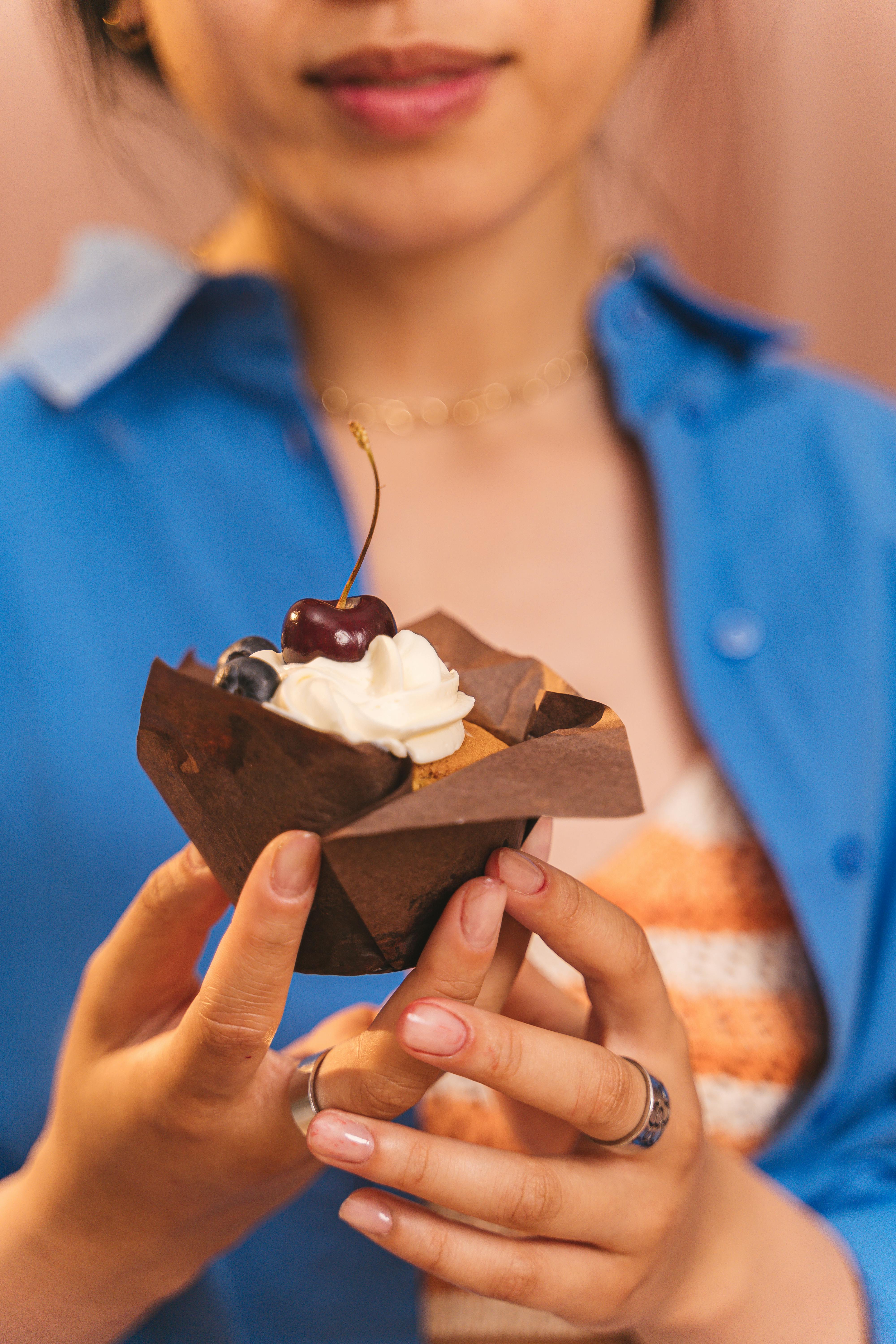 Eine Frau hält einen Cupcake | Quelle: Pexels