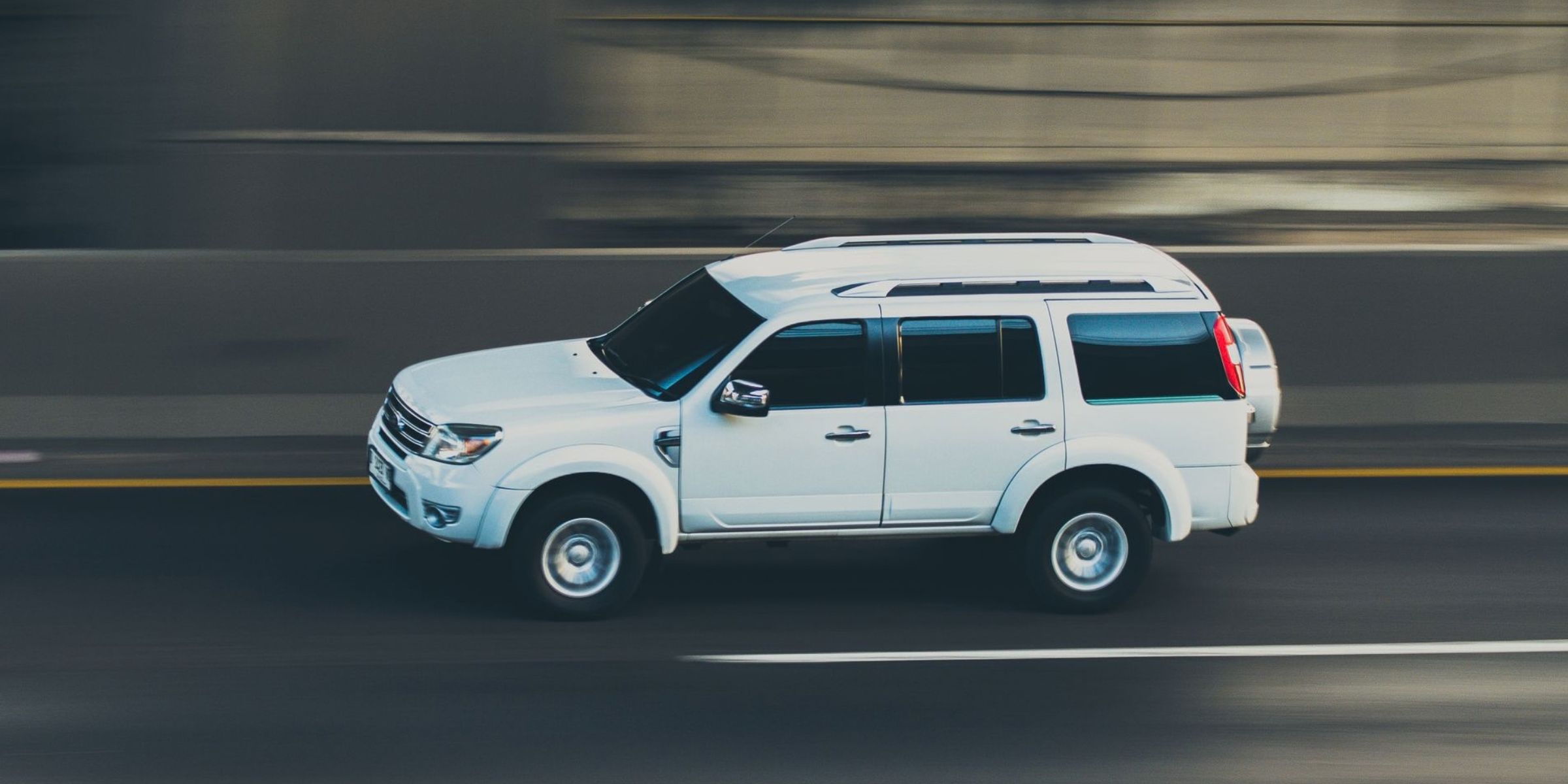 Weißer SUV rast die Straße entlang | Quelle: Pexels