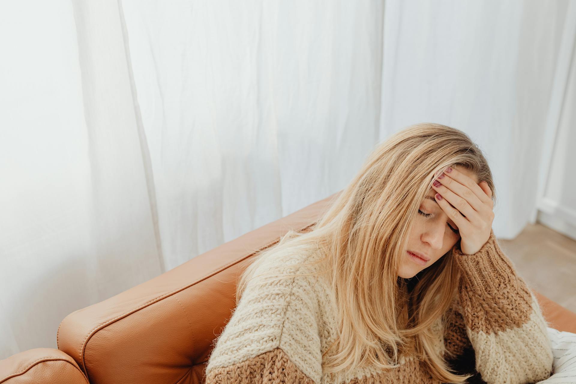 Eine müde Frau, die auf einer Couch sitzt | Quelle: Pexels