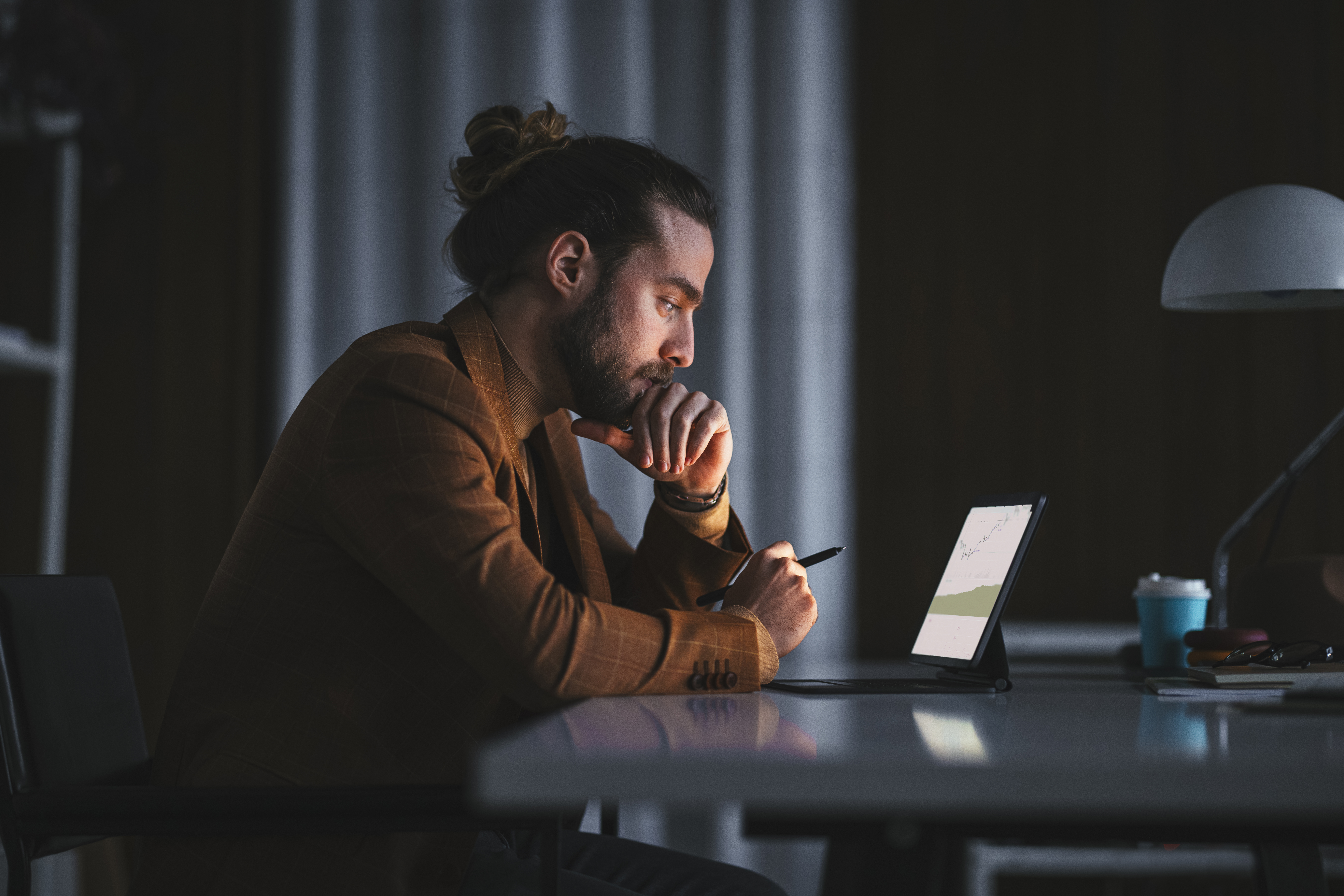 Nachdenklicher Mann bei der Arbeit am Laptop im Büro | Quelle: Getty Images