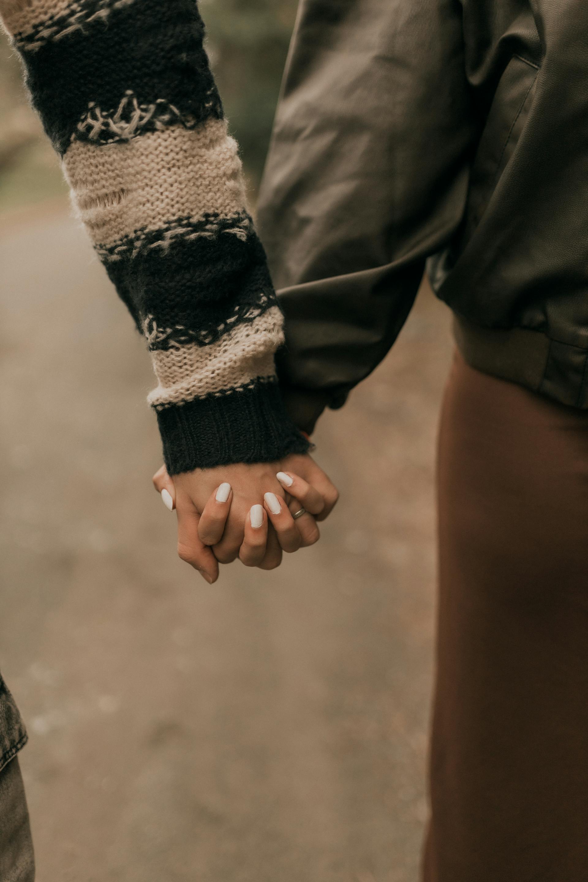 Eine Nahaufnahme eines Paares, das sich im Freien an den Händen hält | Quelle: Pexels
