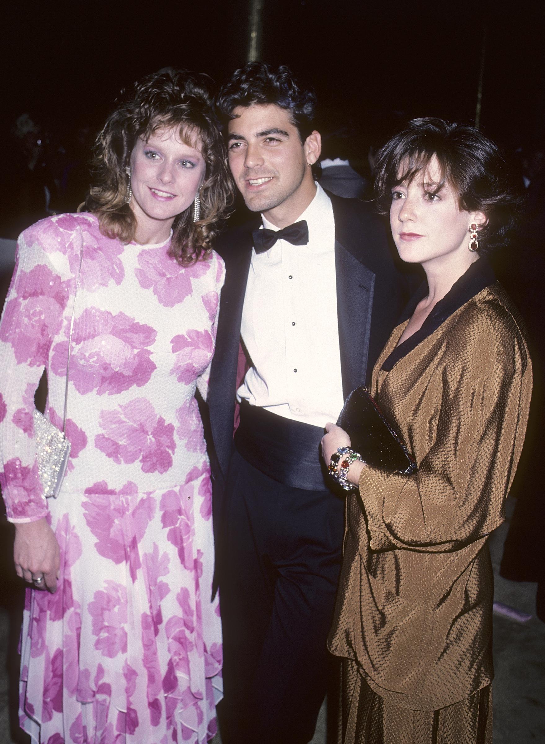 George Clooney und Talia Balsam besuchen den First Annual Singers' Salute to the Songwriter mit einer Freundin am 7. April 1986 | Quelle: Getty Images