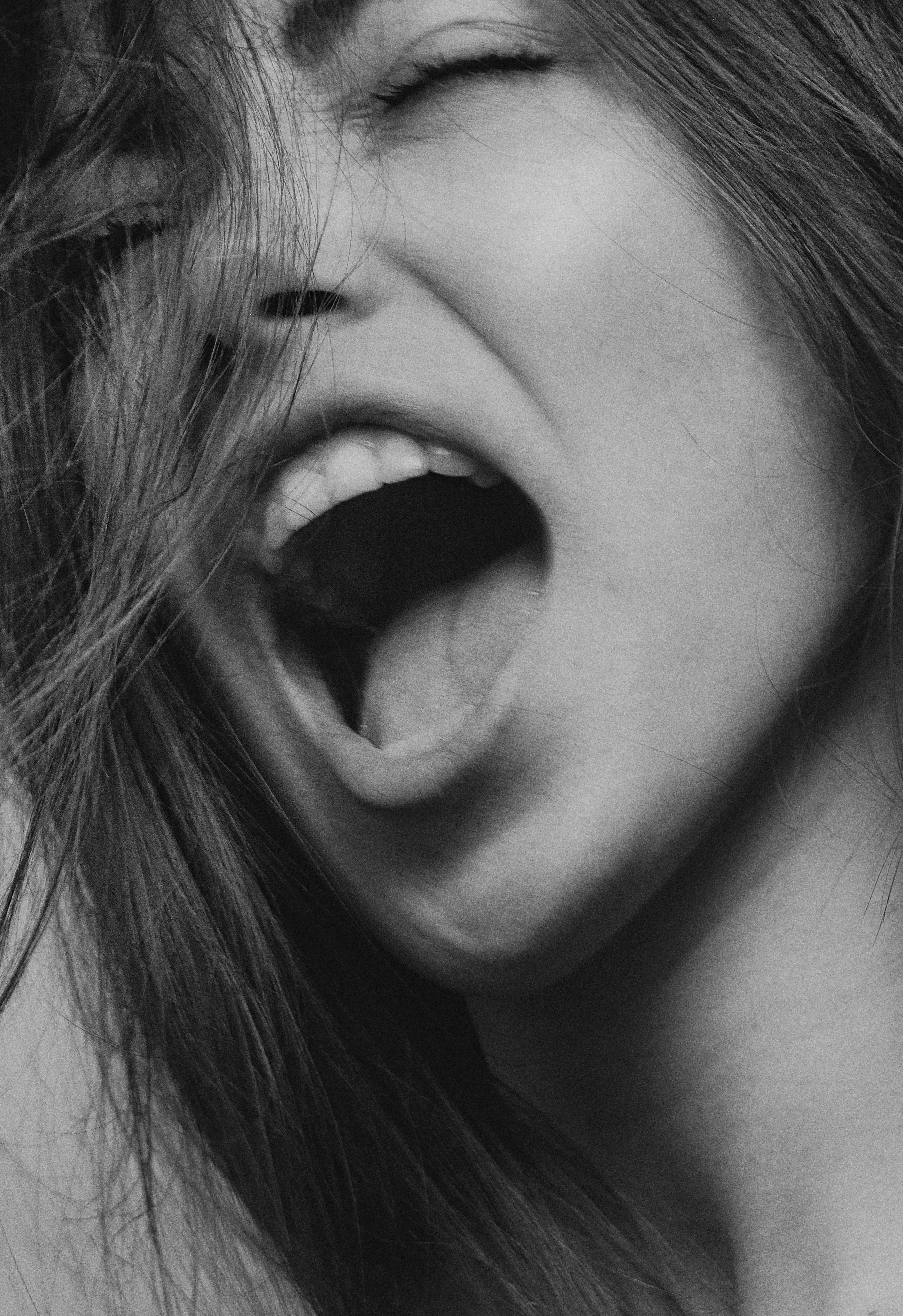 Eine Frau, die mit offenem Mund und geschlossenen Augen schreit | Quelle: Pexels