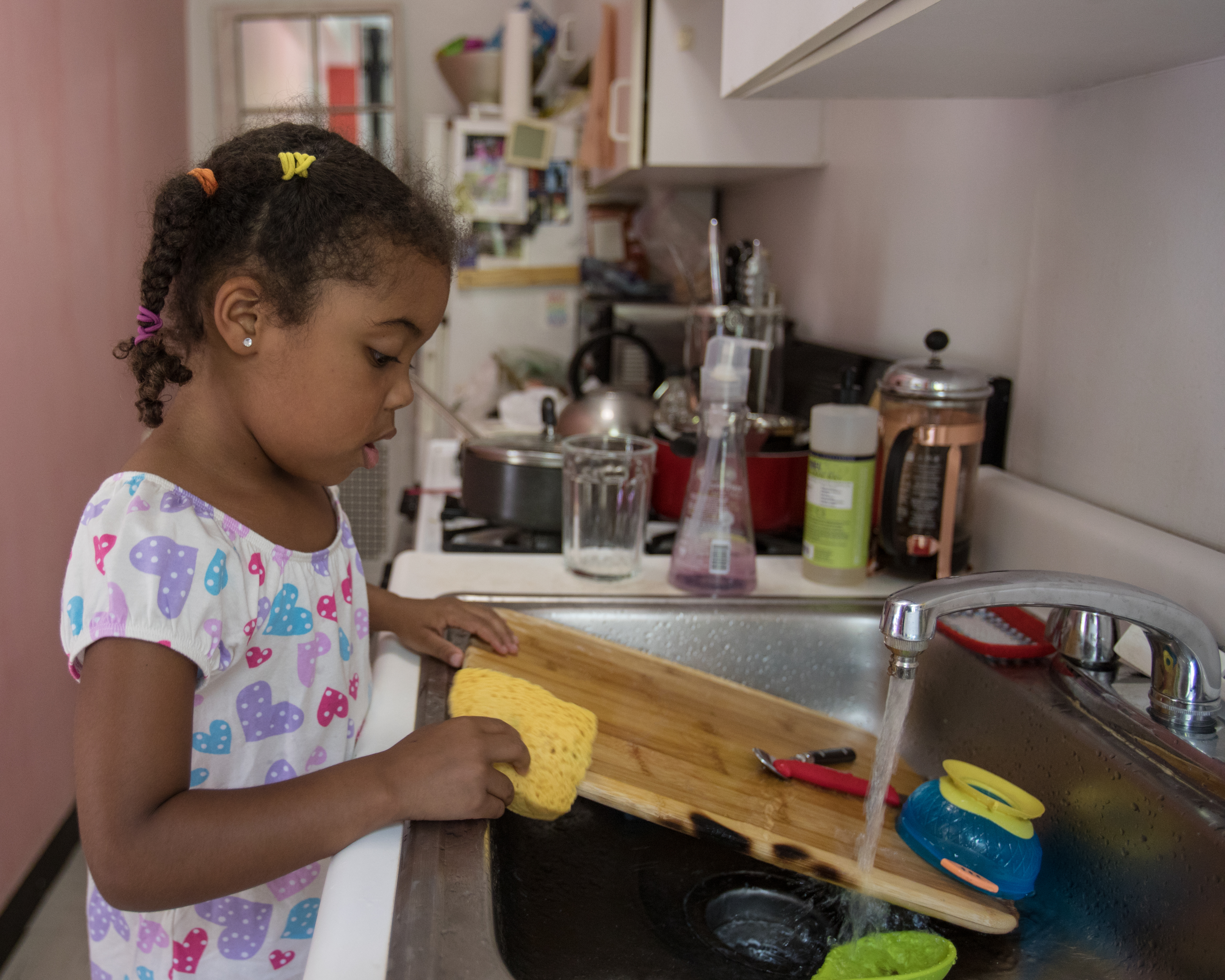 Ein junges Mädchen wäscht Geschirr in einer Küche ab | Quelle: Getty Images