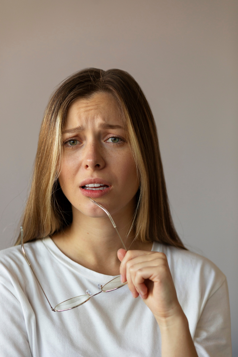 Eine Frau, die ihre Brille festhält und unfreundlich starrt | Quelle: Freepik