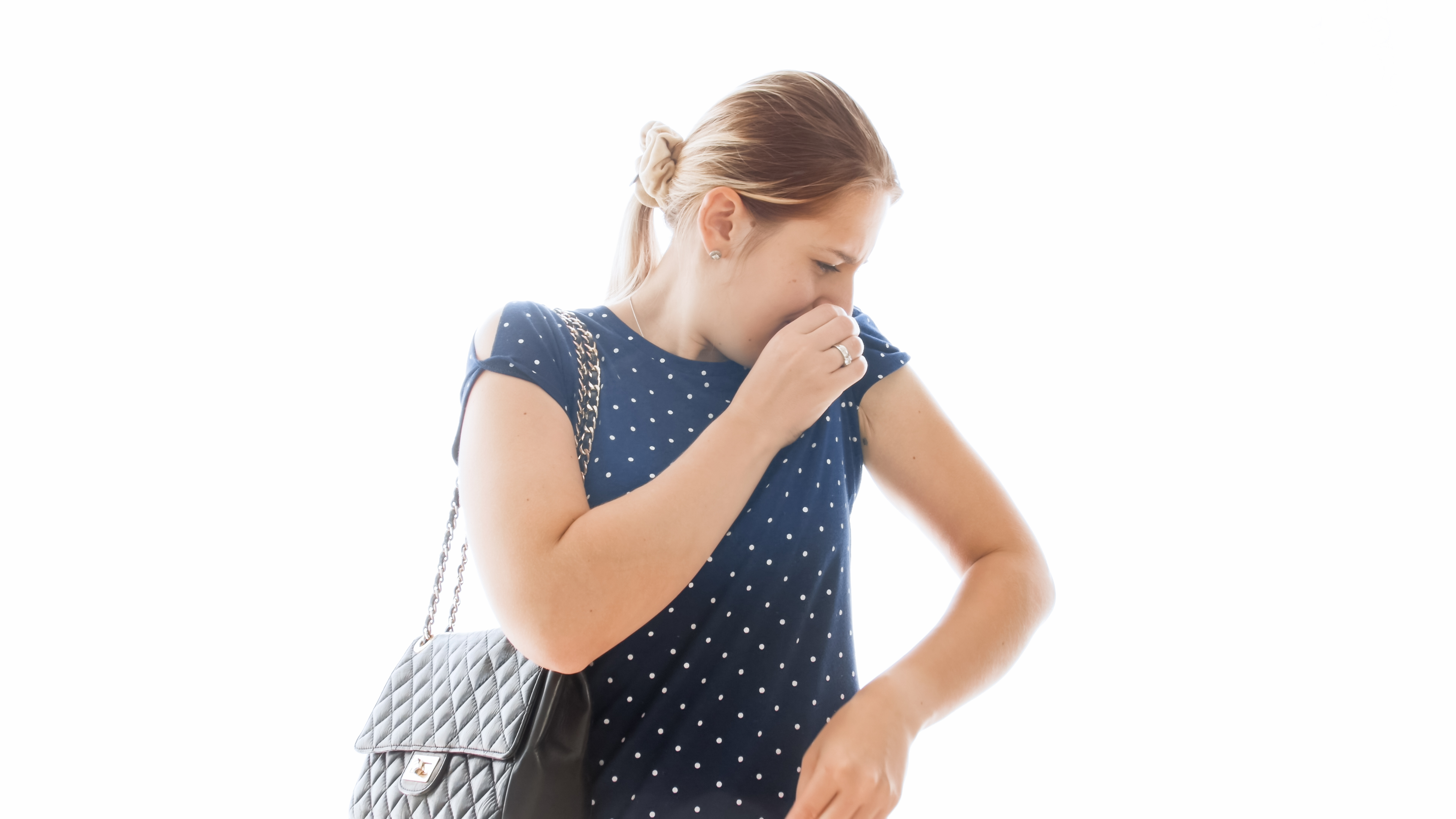 Frau riecht an ihrer Kleidung | Quelle: Shutterstock