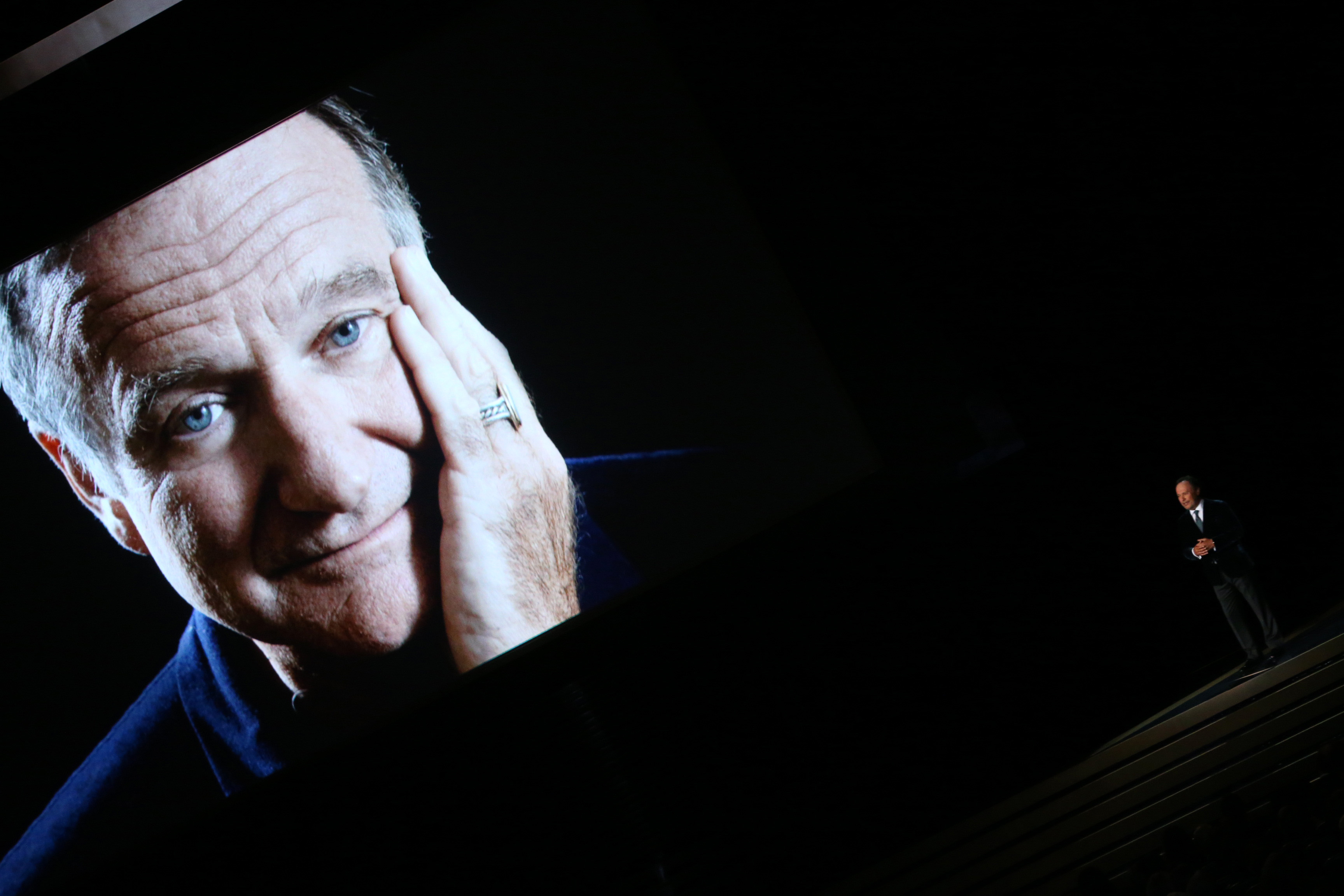 Ein Bild des verstorbenen Robin Williams erscheint, während der Komiker Billy Crystal während der 66th Annual Primetime Emmy Awards am 25. August 2014 spricht | Quelle: Getty Images