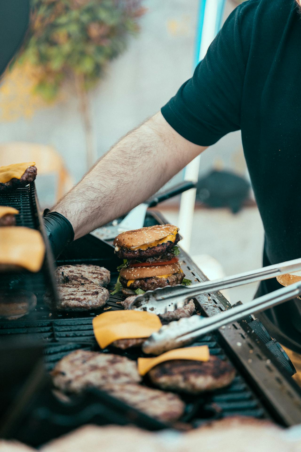 Ein Mann beim Grillen von Burgern | Quelle: Pexels