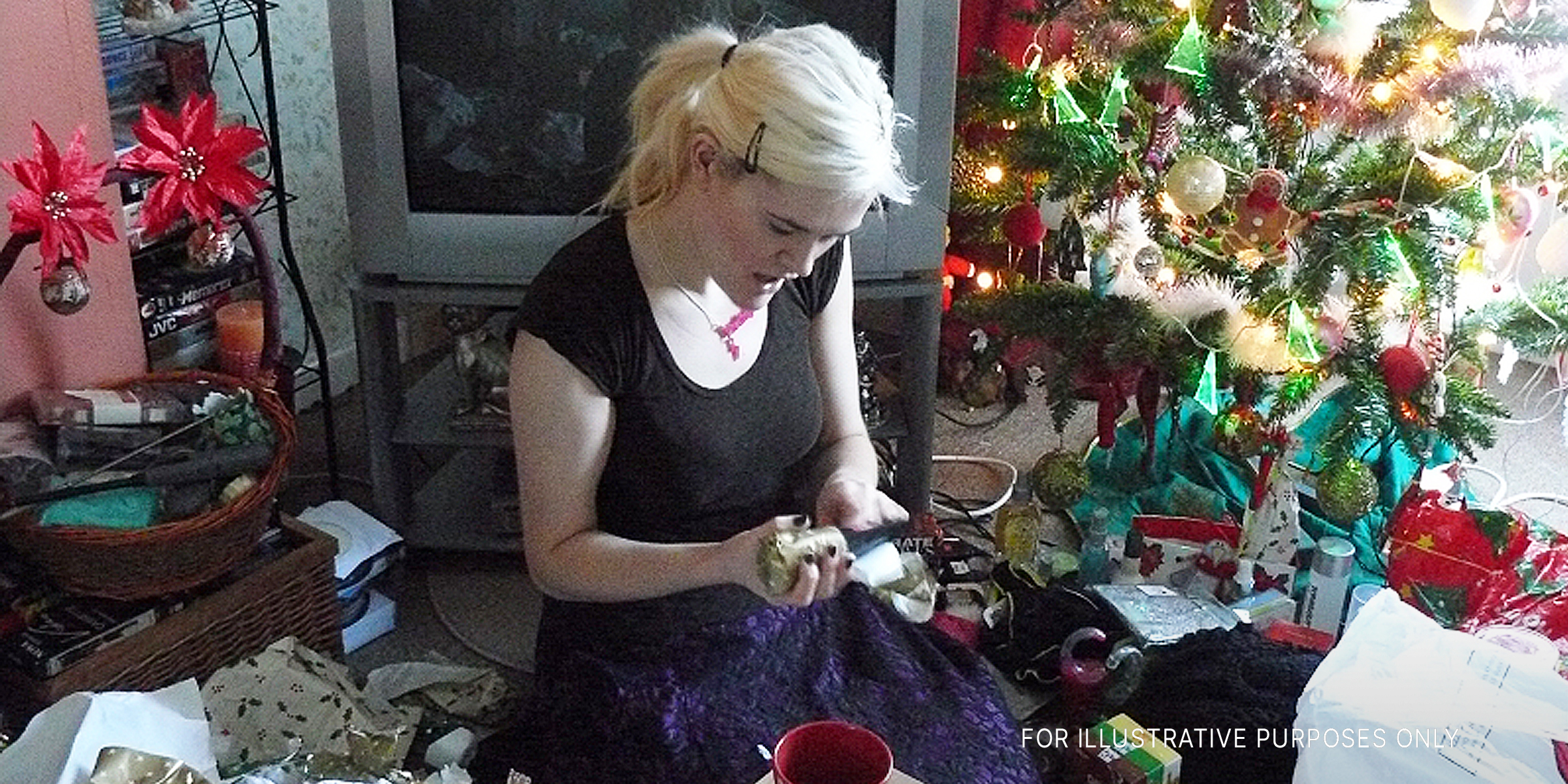 Eine junge Frau packt ein Weihnachtsgeschenk aus | Quelle: flickr.com/flem007_uk/CC BY-ND 2.0