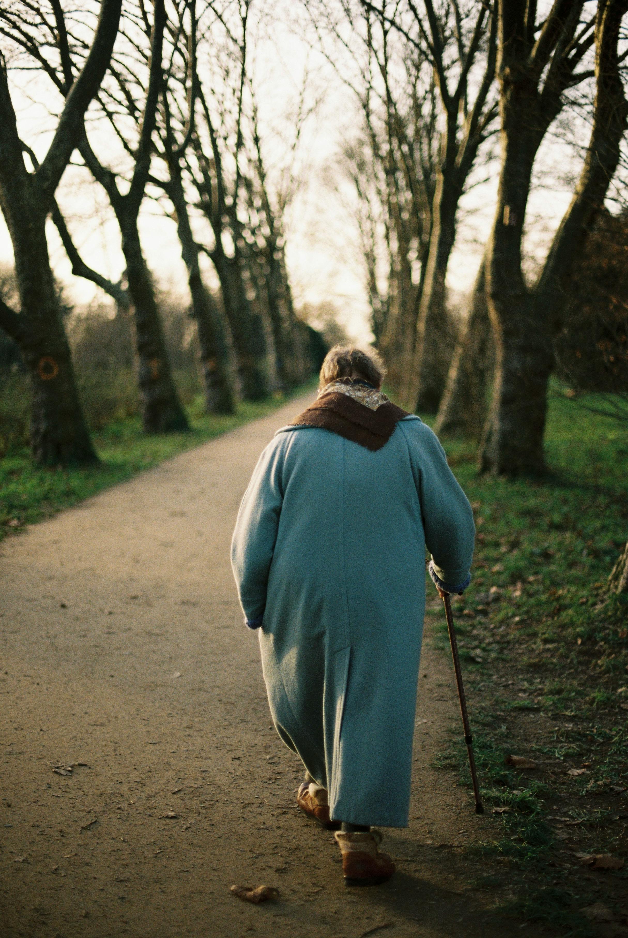 Uma mulher idosa caminhando em um parque | Fonte: Pexels