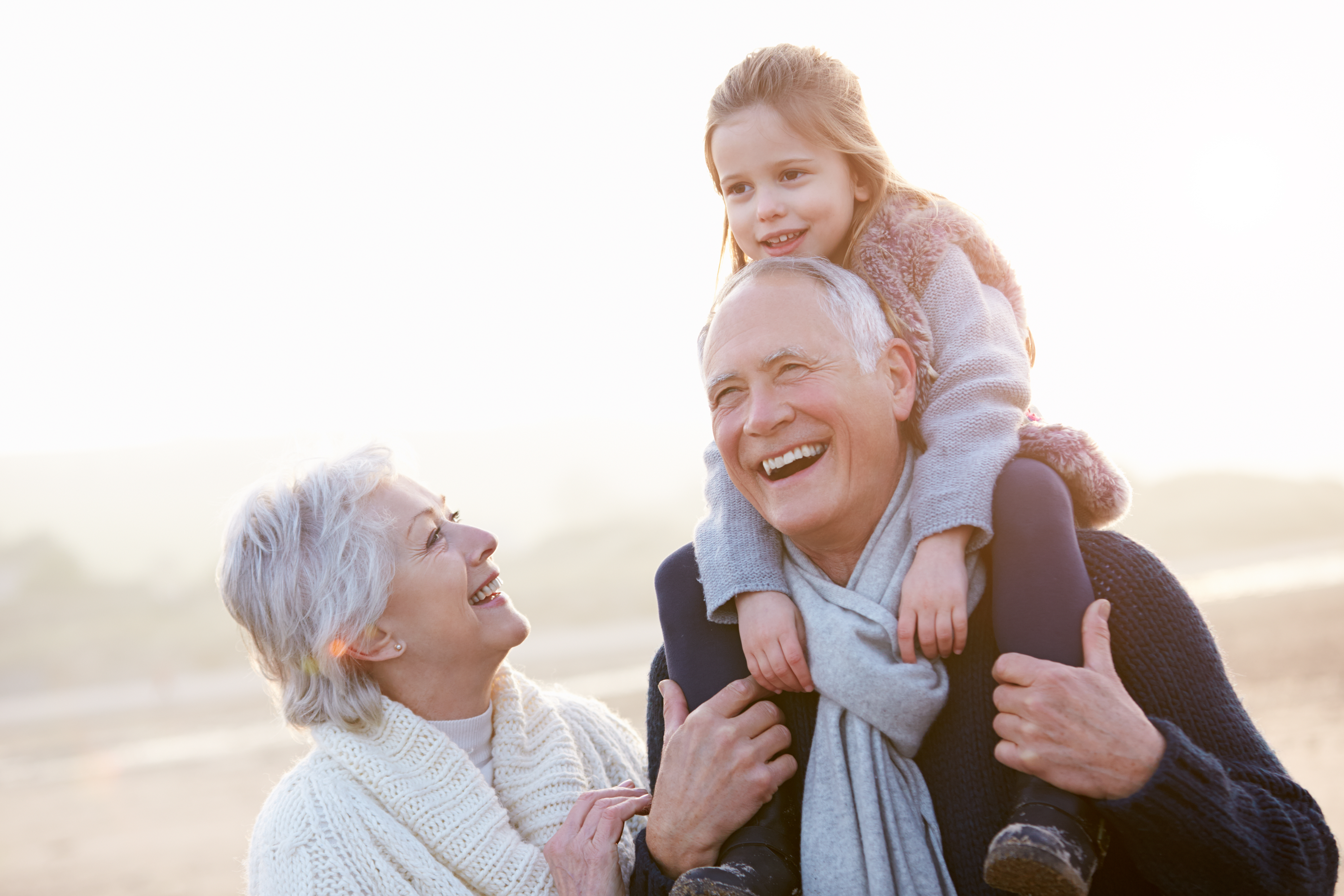 Eine Großmutter lacht, während ihr Mann ihr Enkelkind auf den Schultern trägt | Quelle: Shutterstock