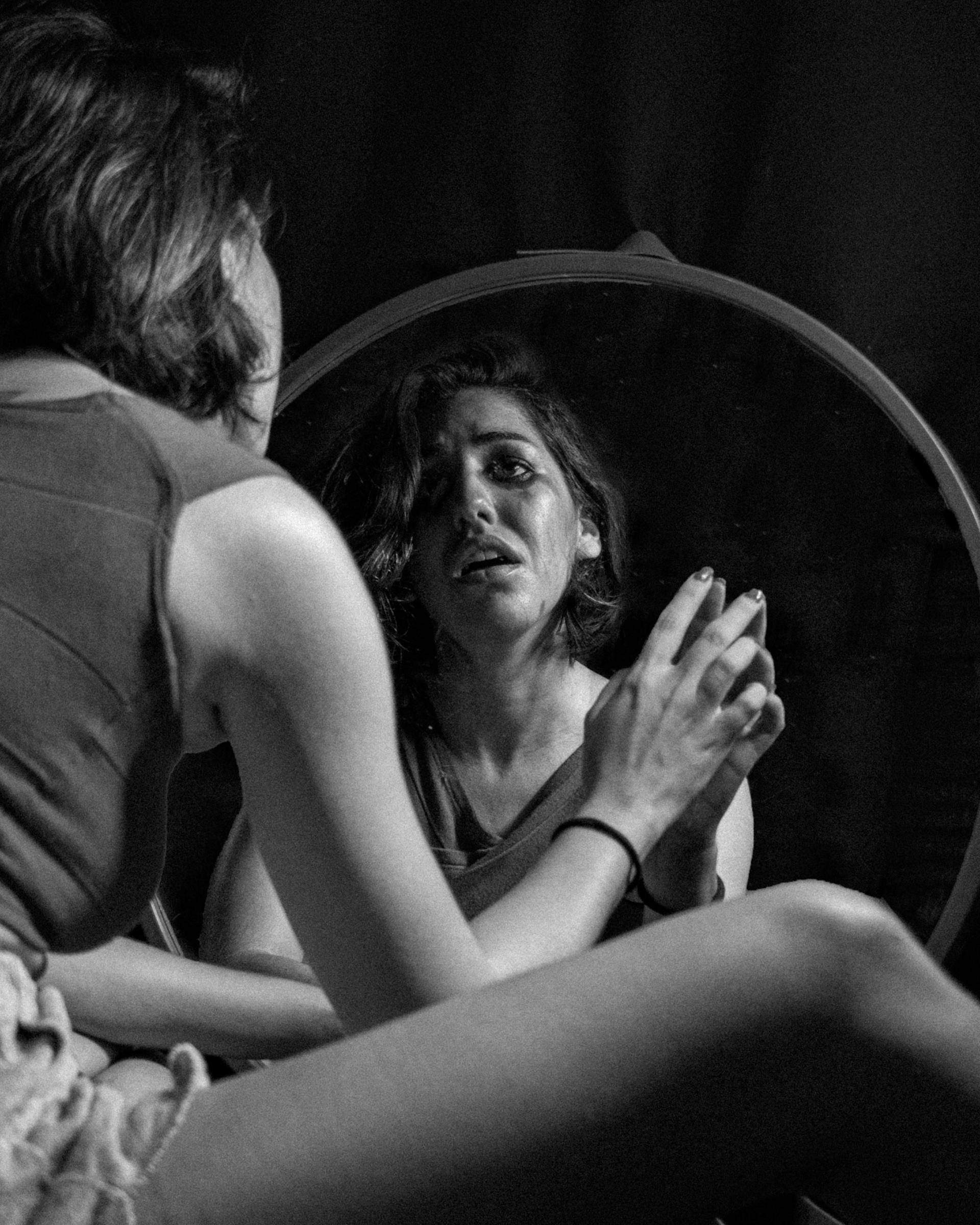 Ein Graustufenfoto von einer weinenden Frau, die in den Spiegel schaut | Quelle: Pexels