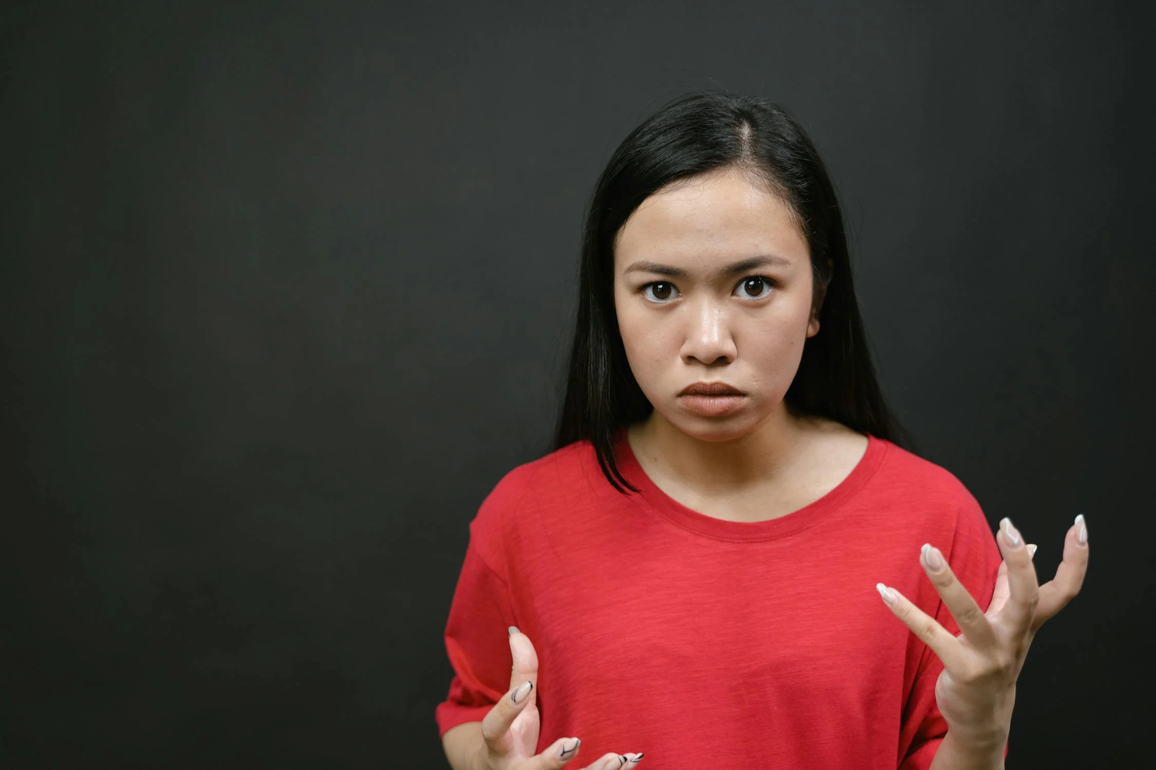 Eine stirnrunzelnde junge Frau | Quelle: Pexels