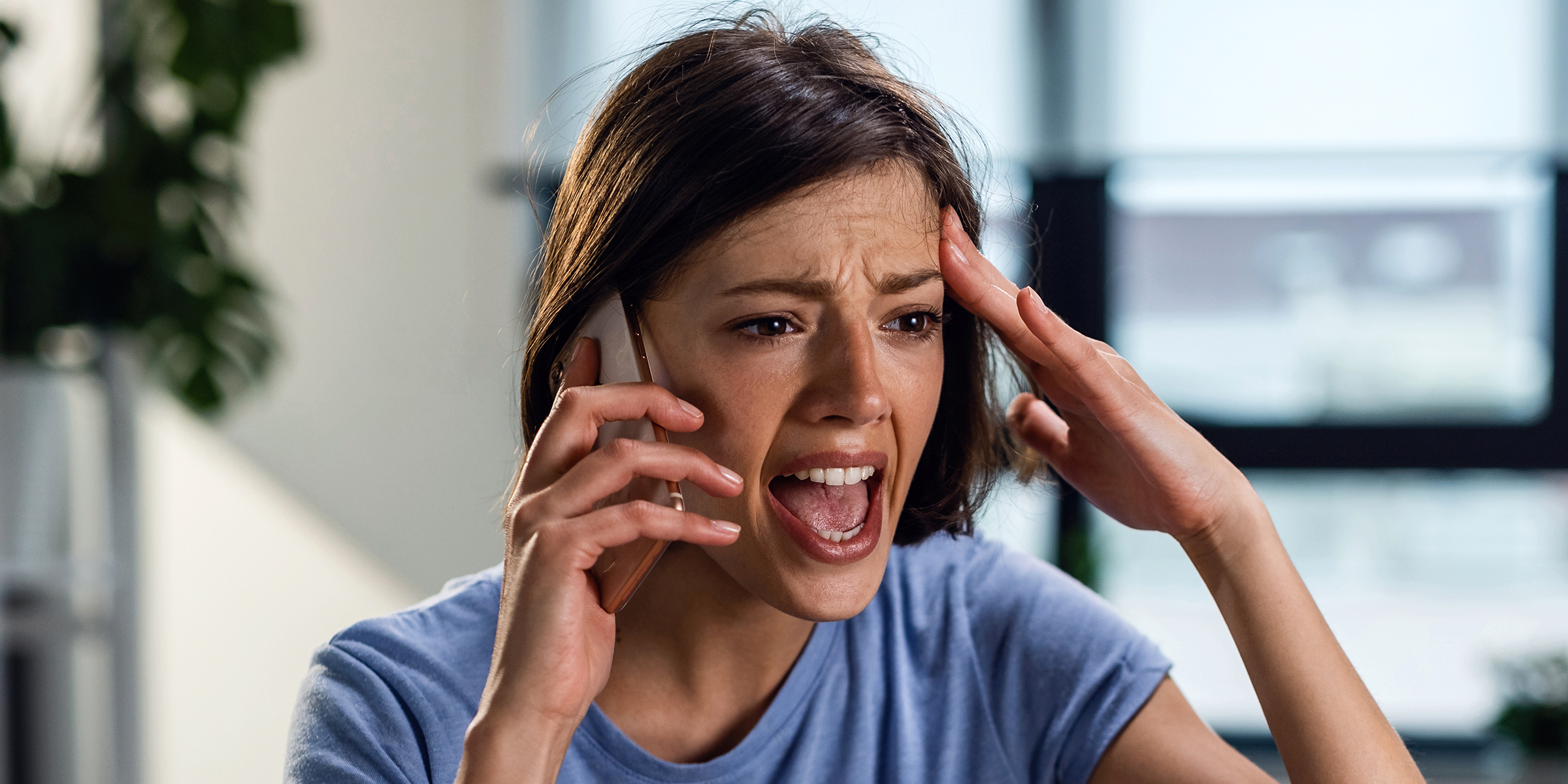 Eine geschockte Frau, die in ihr Telefon spricht | Quelle: Shutterstock